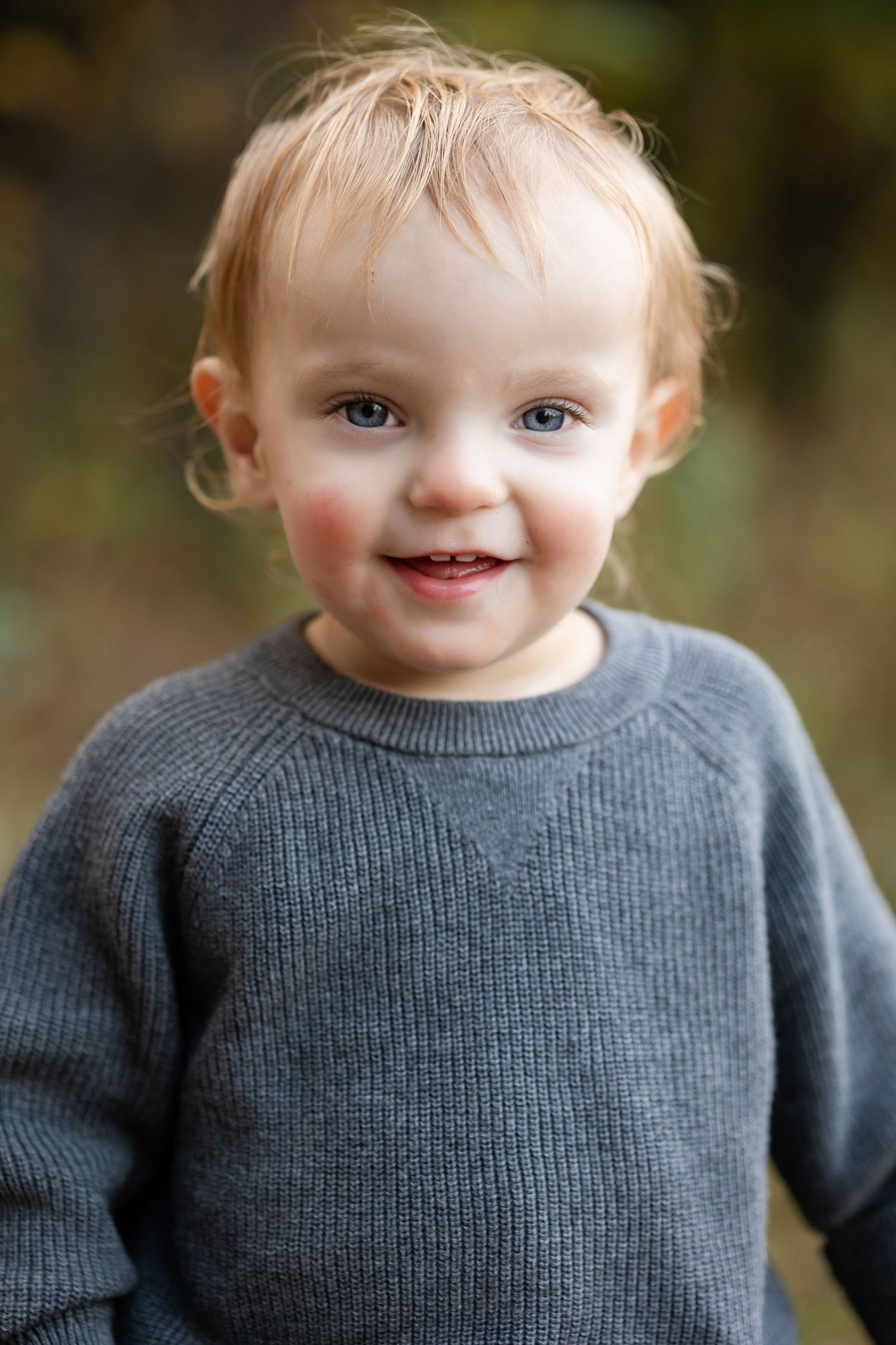 Close-up portrait sequence showing joyful expressions while wearing a gray sweater in natural lighting.
