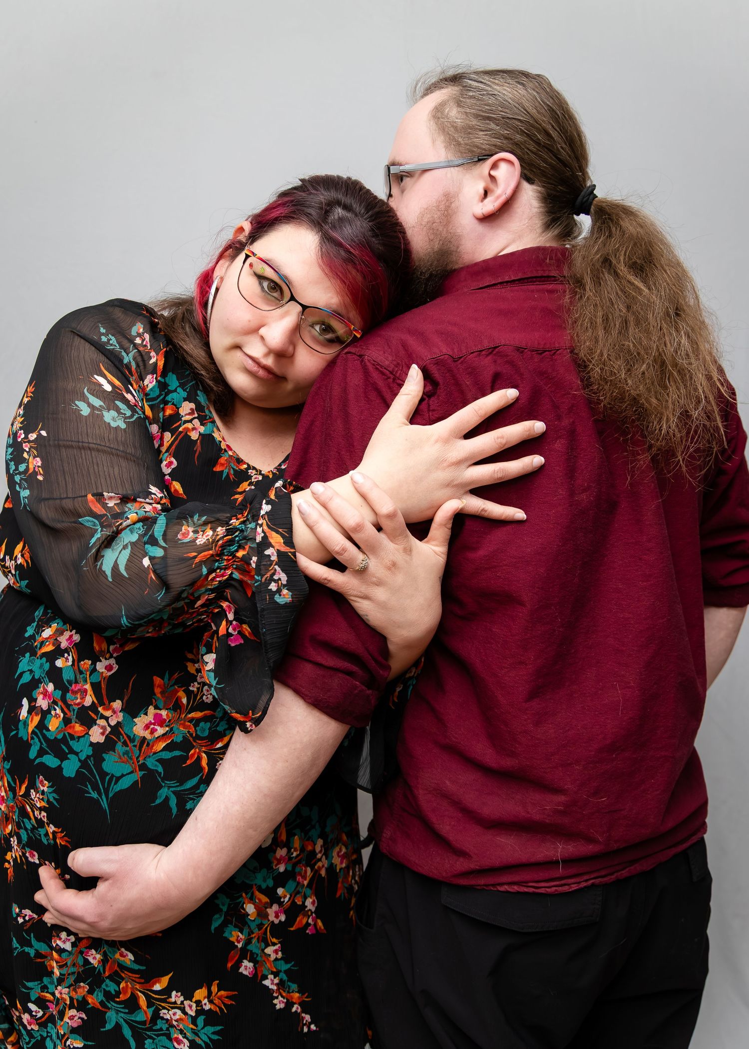 A couple in a floral dress and burgundy shirt pose playfully in a sequence of four candid photo booth style shots.