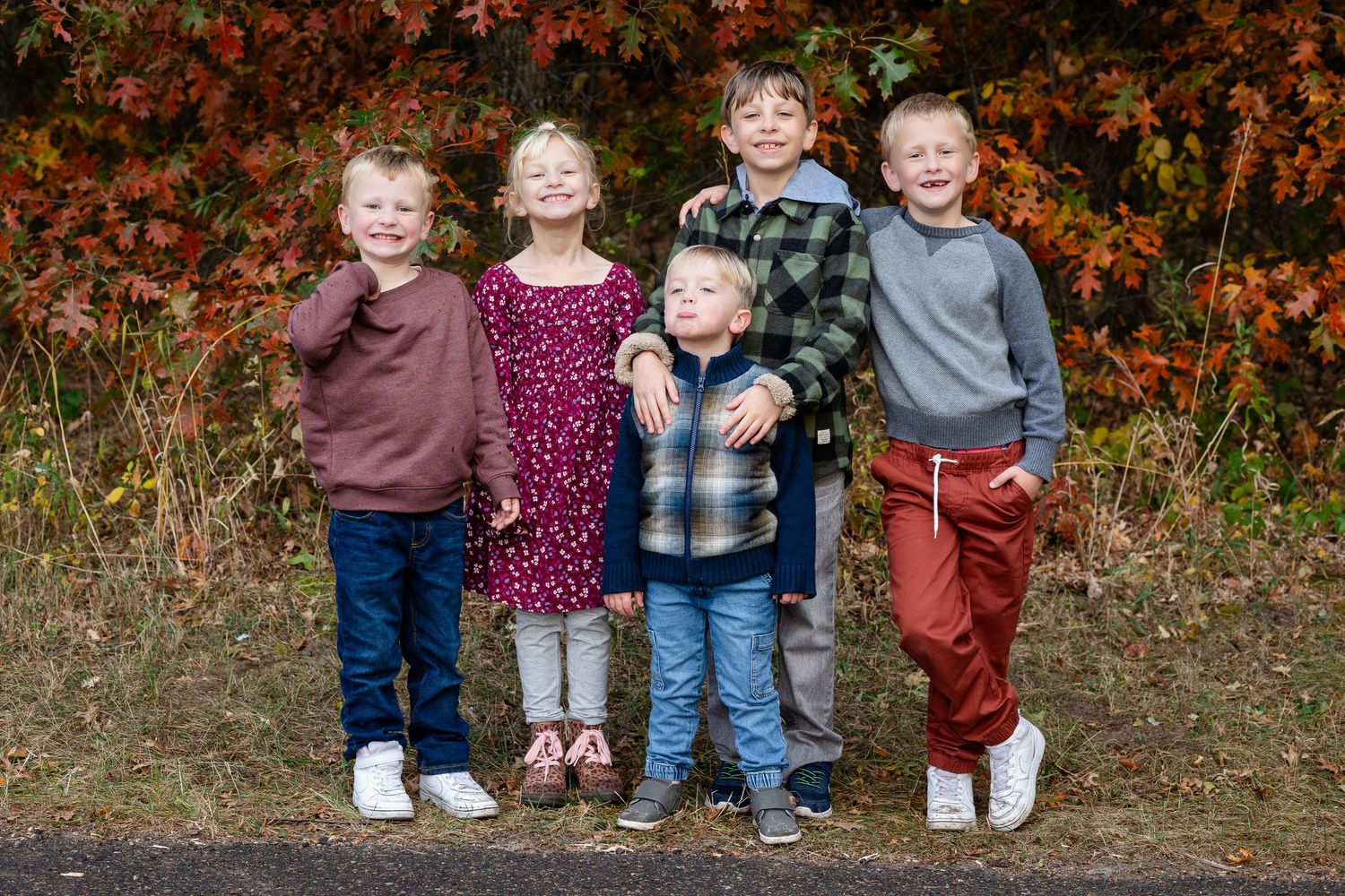 Group portrait with children in autumn outdoor setting.