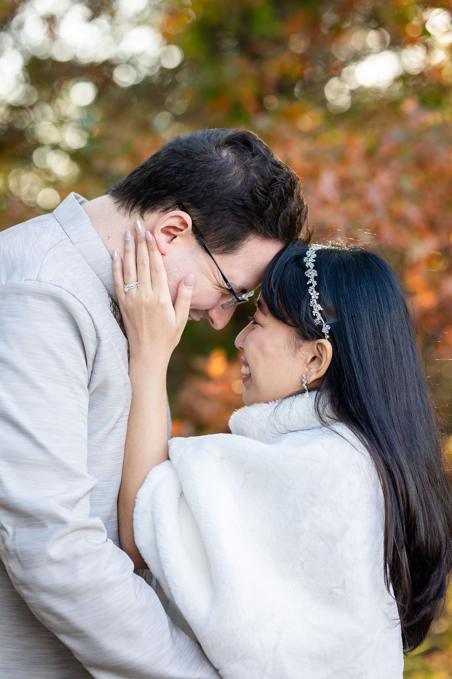 A tender moment between a couple with autumn colors in the background.