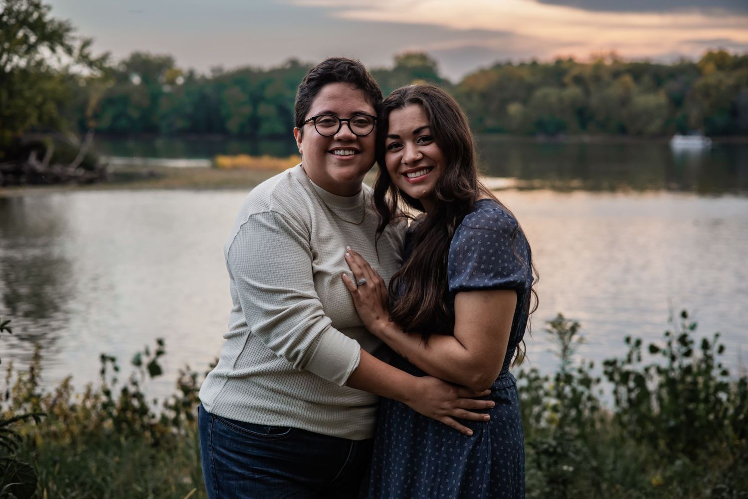 Romantic couple shares tender moments by a serene lake at sunset.