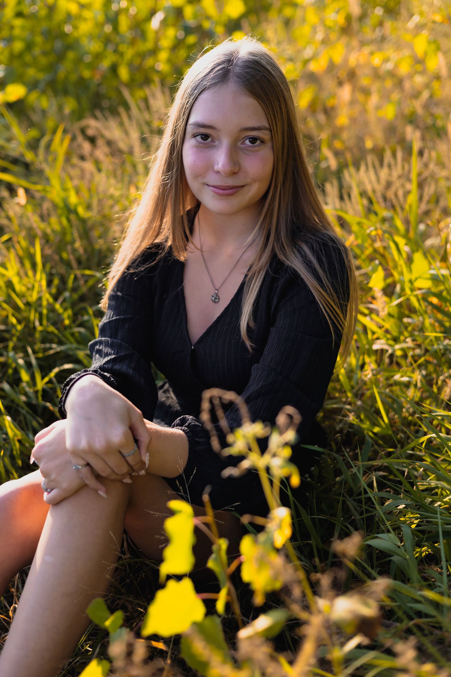 Portrait session in field with golden wildflowers and natural lighting.