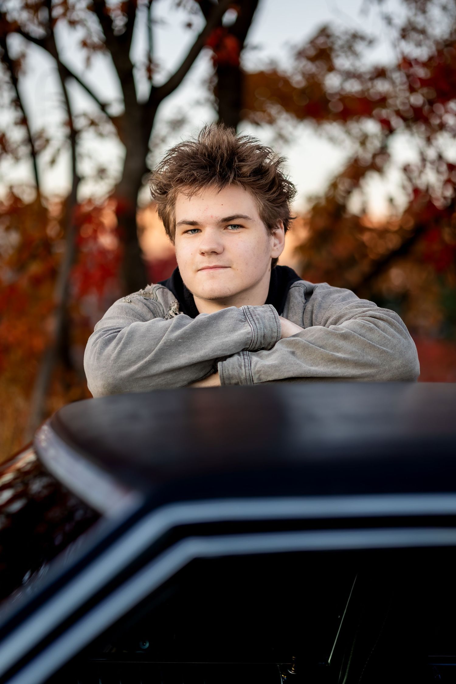 Series of moody portraits taken at dusk showing reflections on a car's black exterior.