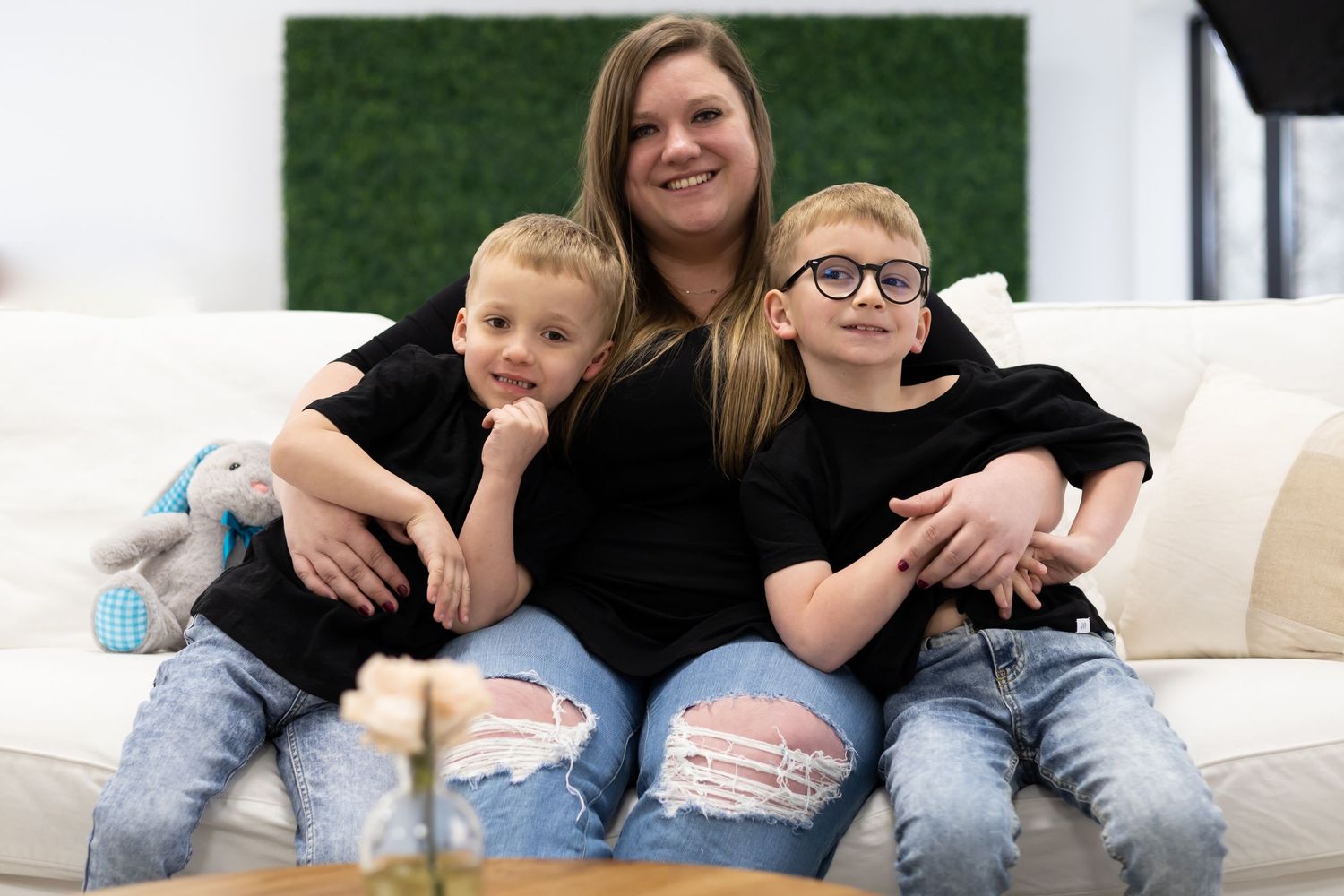 Family members relaxing together on a white couch in casual attire.