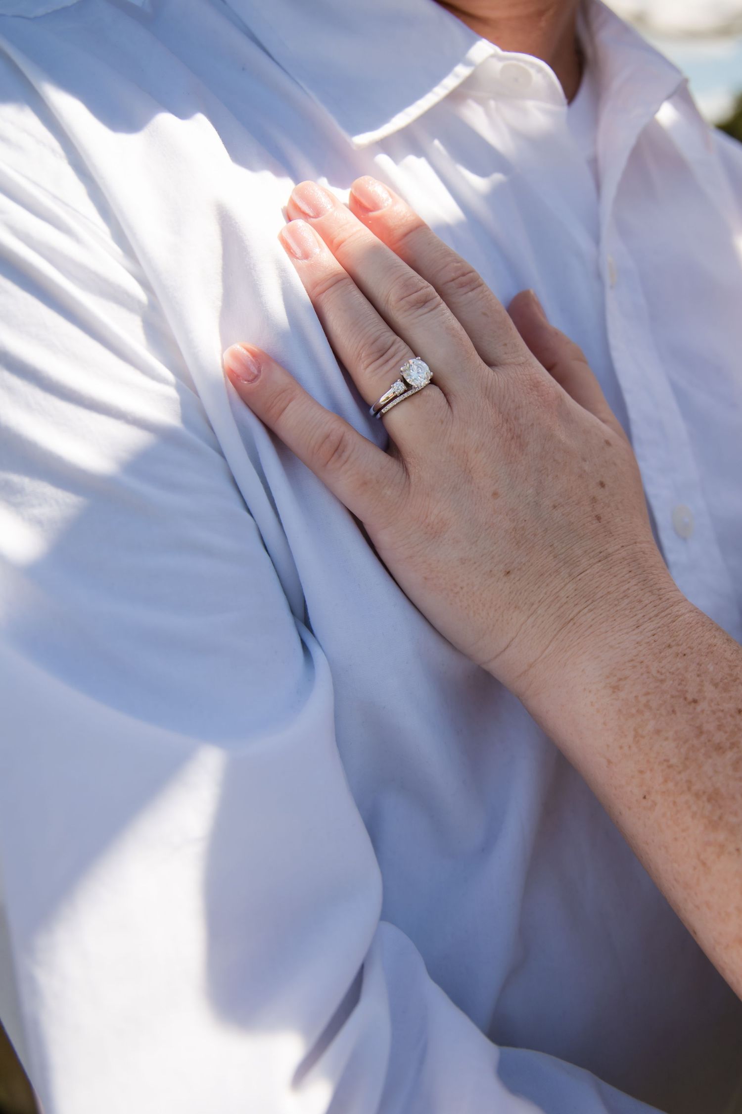 Close-up series of hands showing an engagement ring against a white background.
