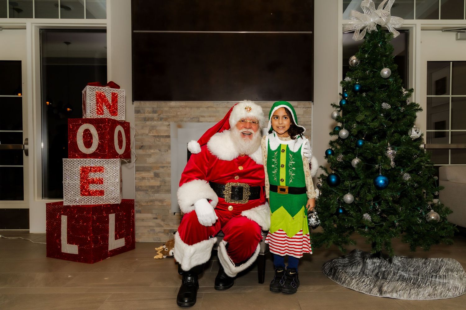 Holiday photo area with Christmas tree, red NOEL letters, and winter decorations.