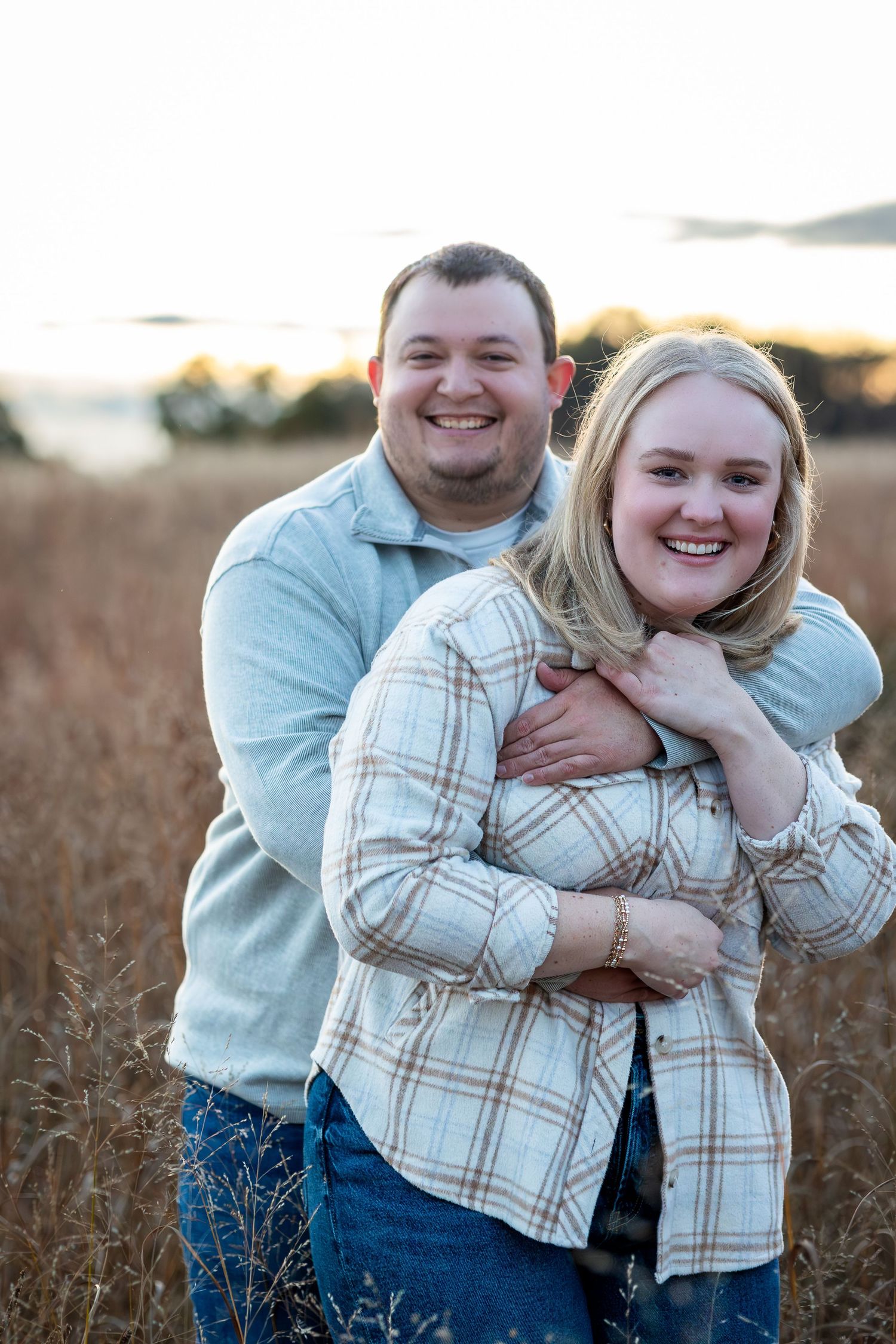 Engagement photos captured in a golden wheat field at sunset.