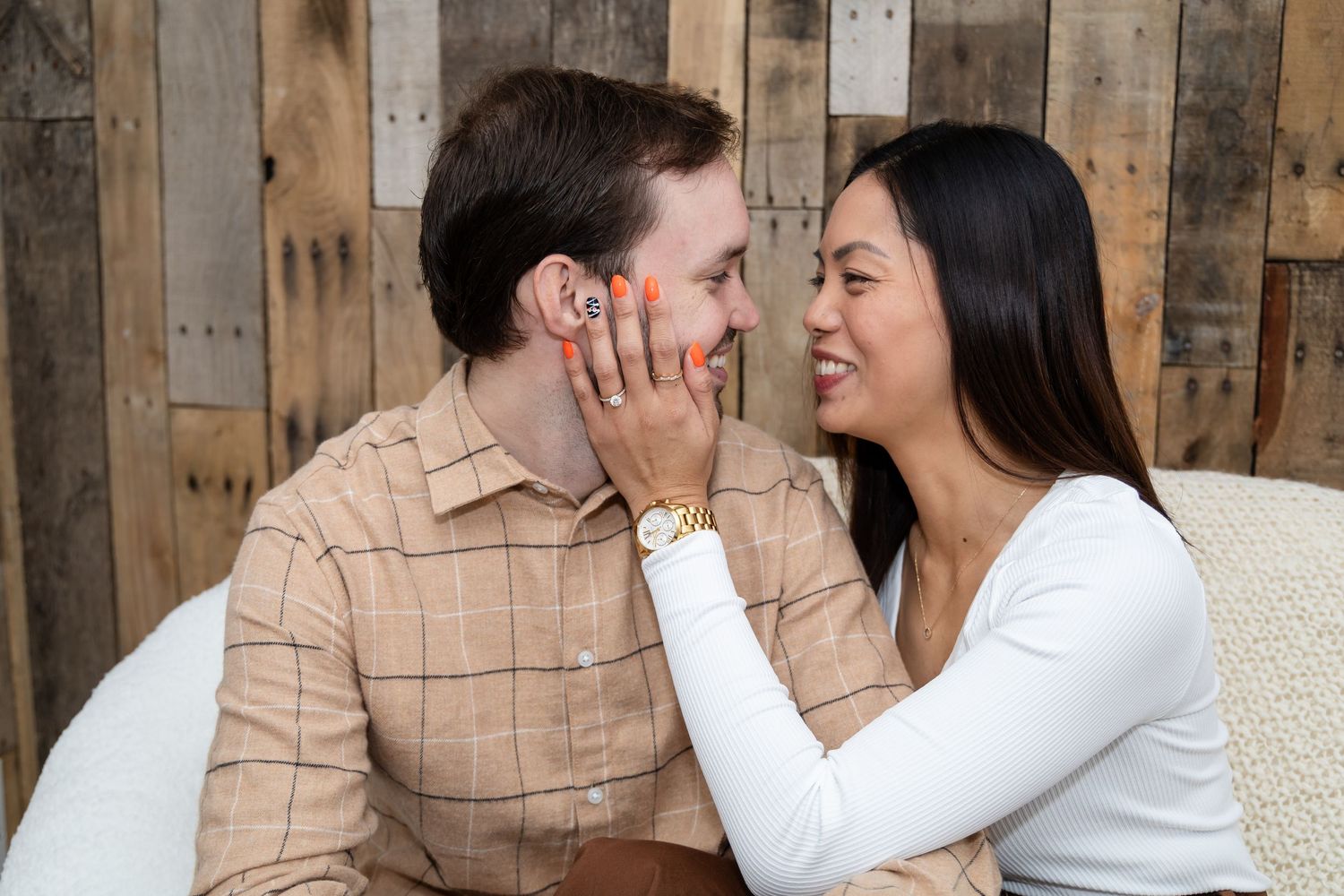 A romantic couple shares intimate moments while sitting on a white sofa.