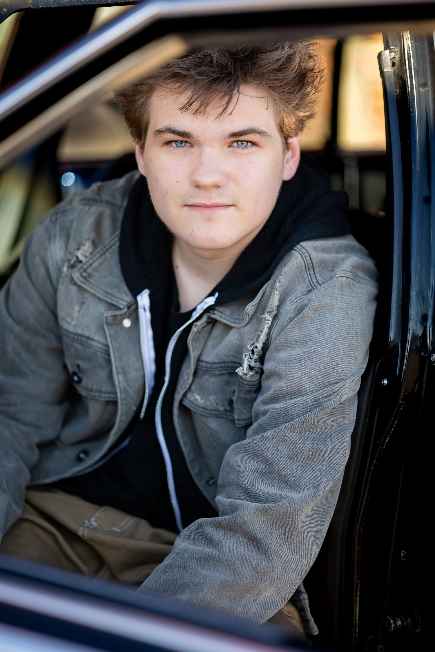 A series of portraits showing someone sitting in the driver's seat of a car wearing a gray jacket.