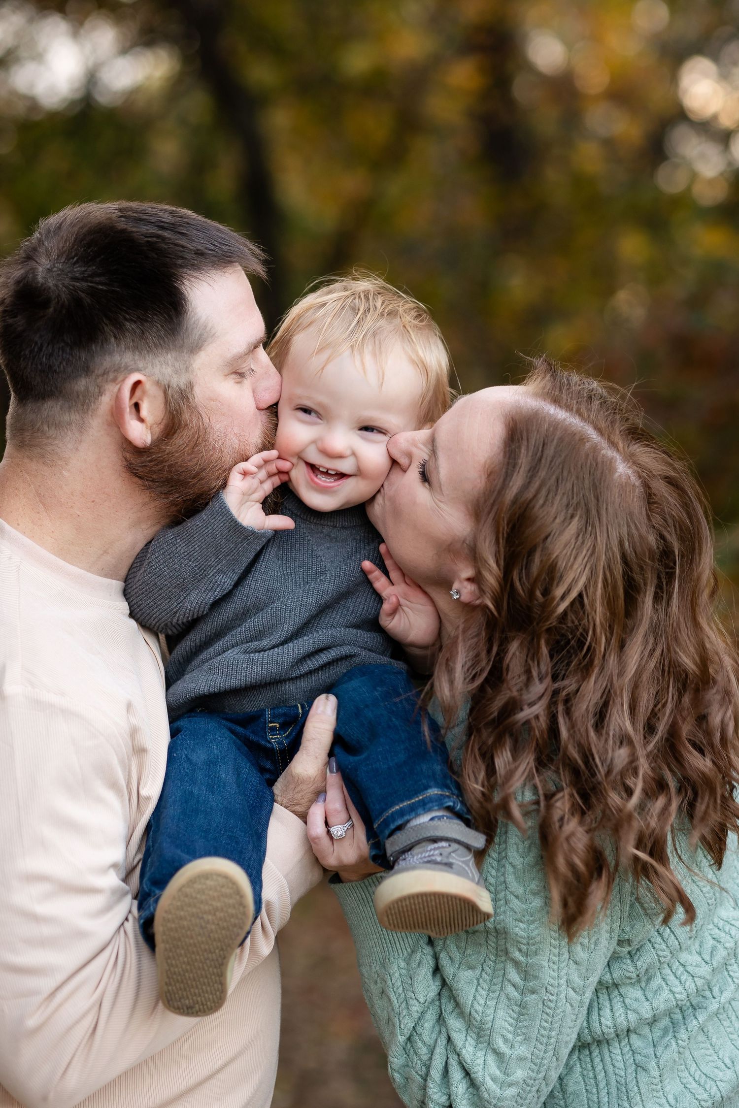 Family sharing intimate moment together in autumn forest setting.