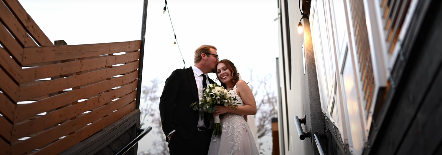 Wedding couple walking through a rustic wooden doorway.