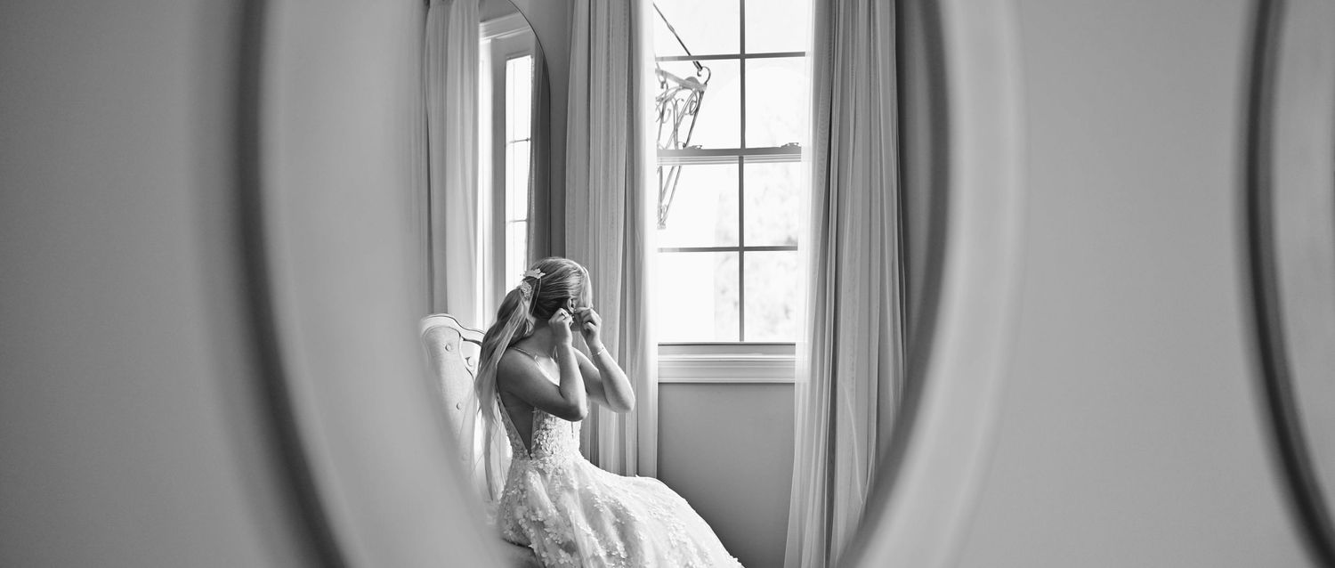 Elegant black and white interior photo featuring tall windows and flowing curtains.