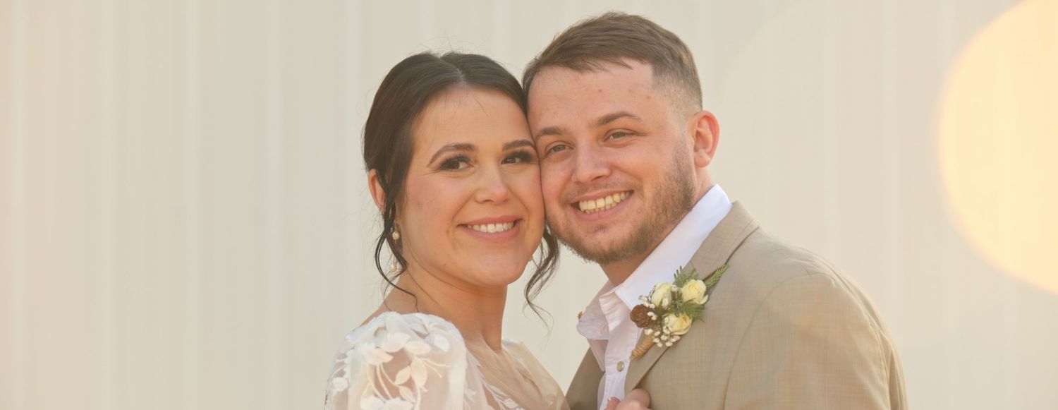 Wedding celebration in a rustic indoor venue with warm lighting and wooden beams.