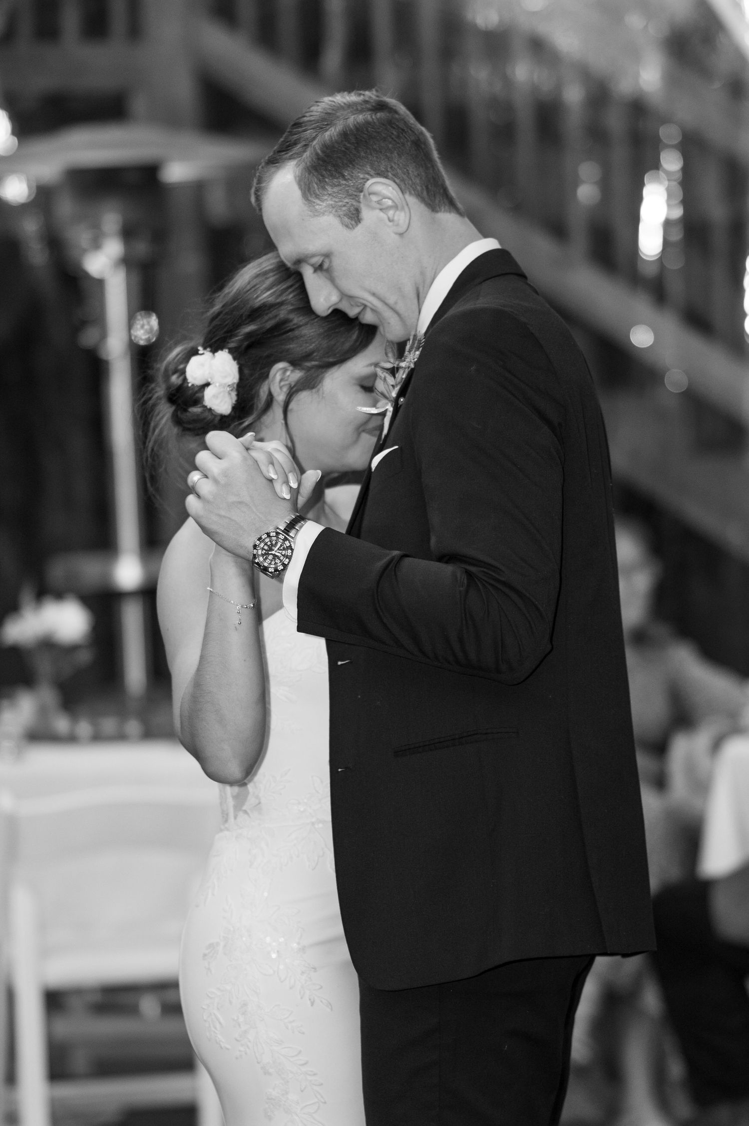 Intimate black and white dance moment at indoor wedding reception.