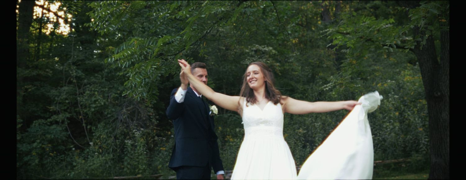 Joyful dancing moment between newlyweds in outdoor garden setting.