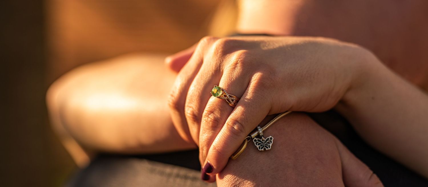 Close-up detail of wedding rings and hands in warm golden light.
