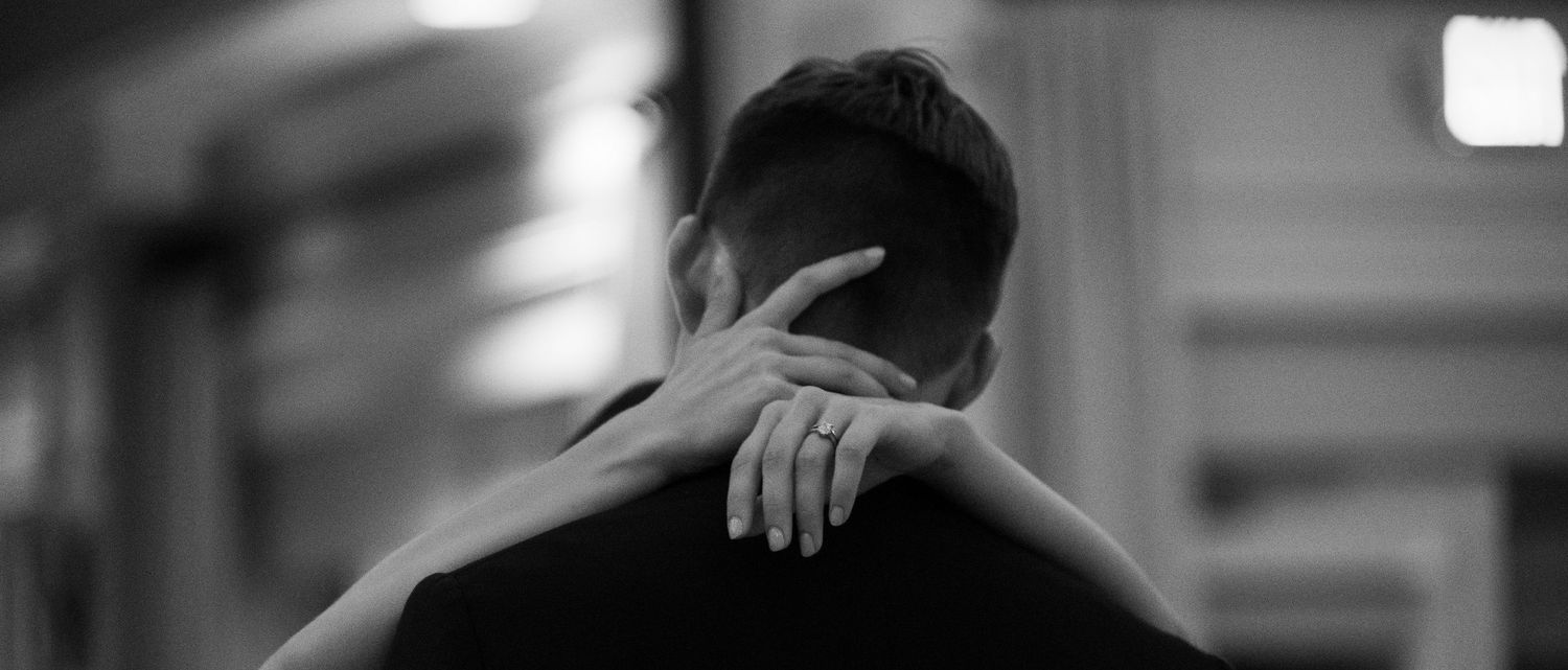 A couple shares an intimate moment during a dance in low lighting.