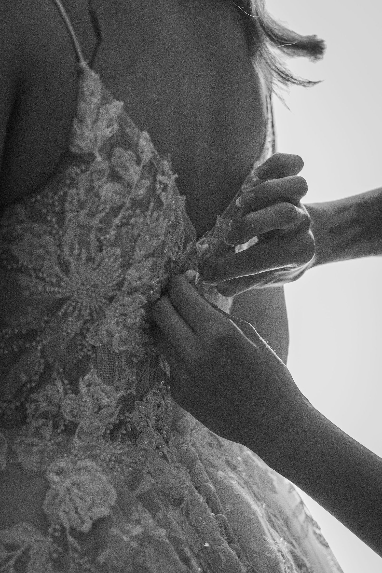 Close-up details of delicate lace and beading on an elegant white wedding dress.
