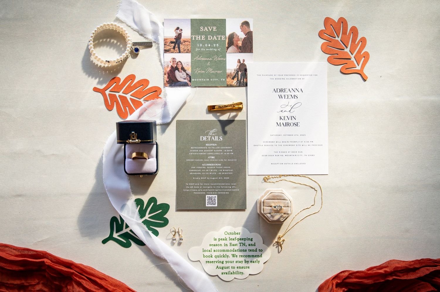 Wedding invitation suite with autumn leaves, menu cards, and decorative elements laid out on a light background.