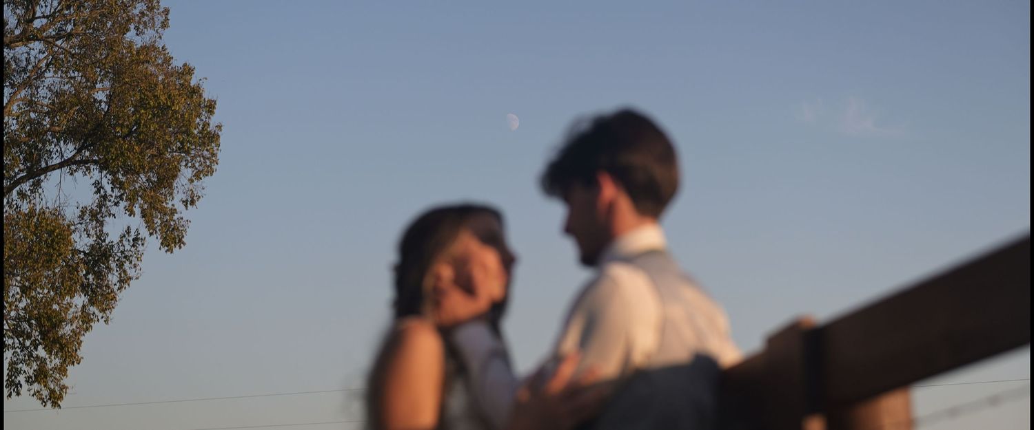 A couple enjoys a scenic mountain overlook on a clear blue day.