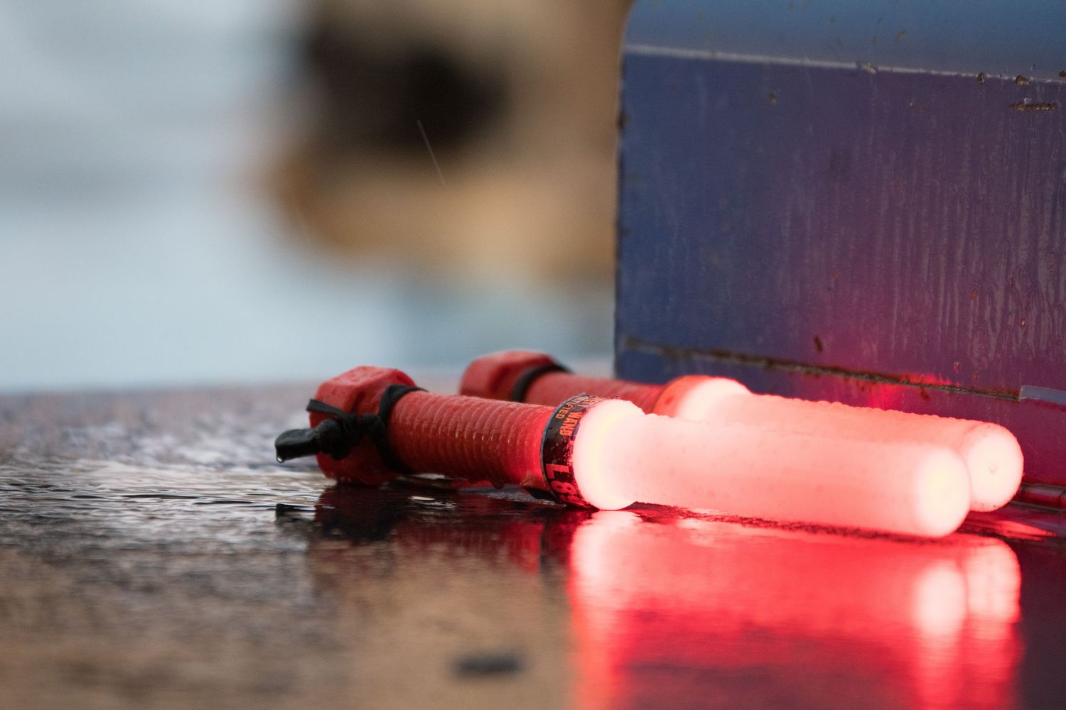 Red glowing lights reflecting off metallic surface in dark environment.