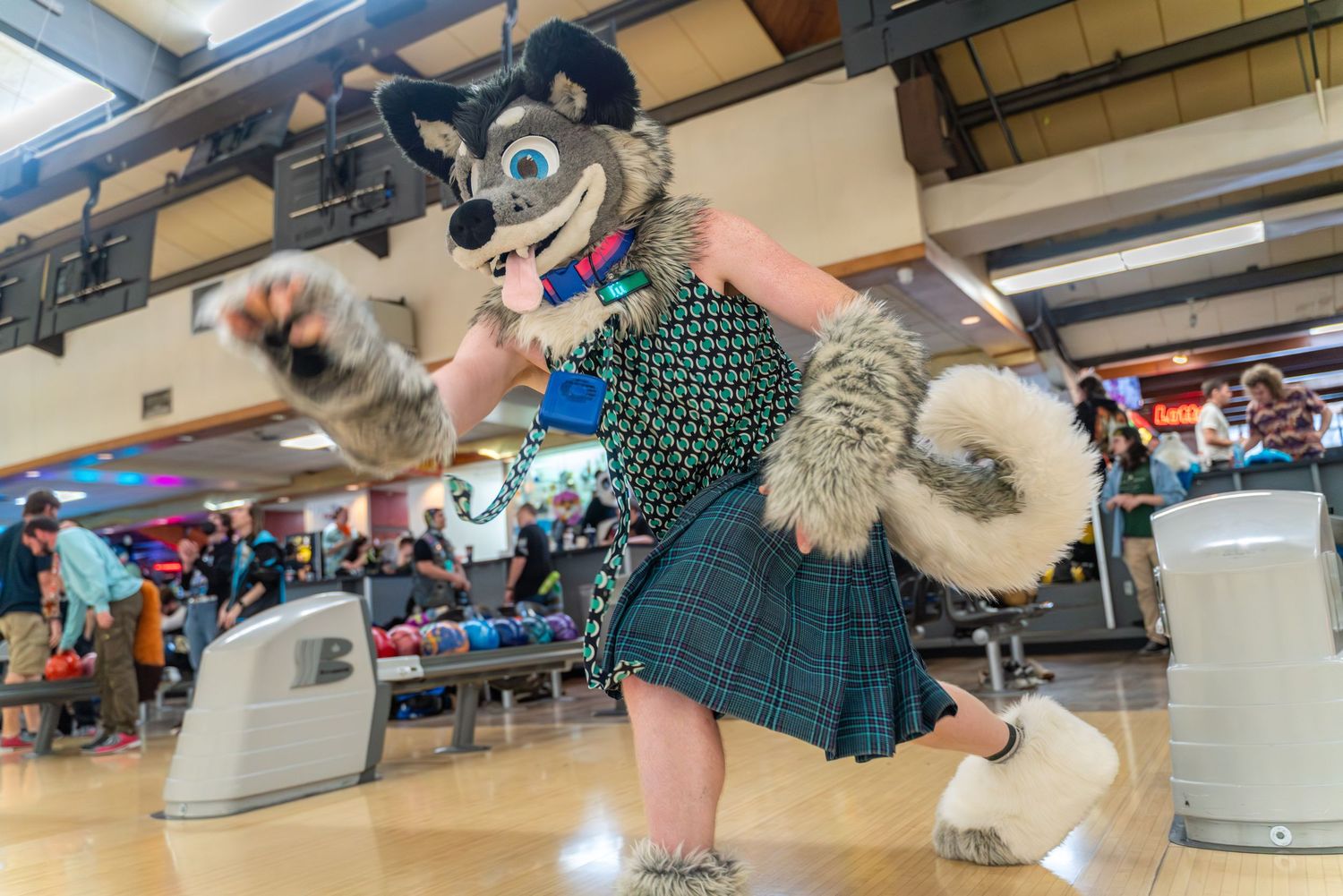 Fursuit characters gathered near bowling lanes during a special event.