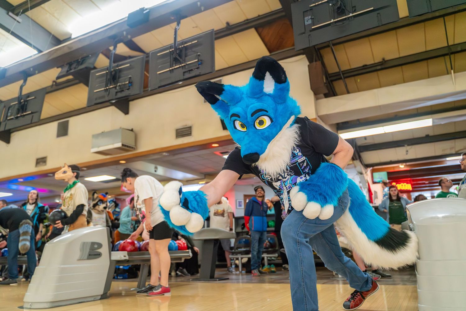 Line of blue fursuited characters arranged diagonally across a bowling alley floor.
