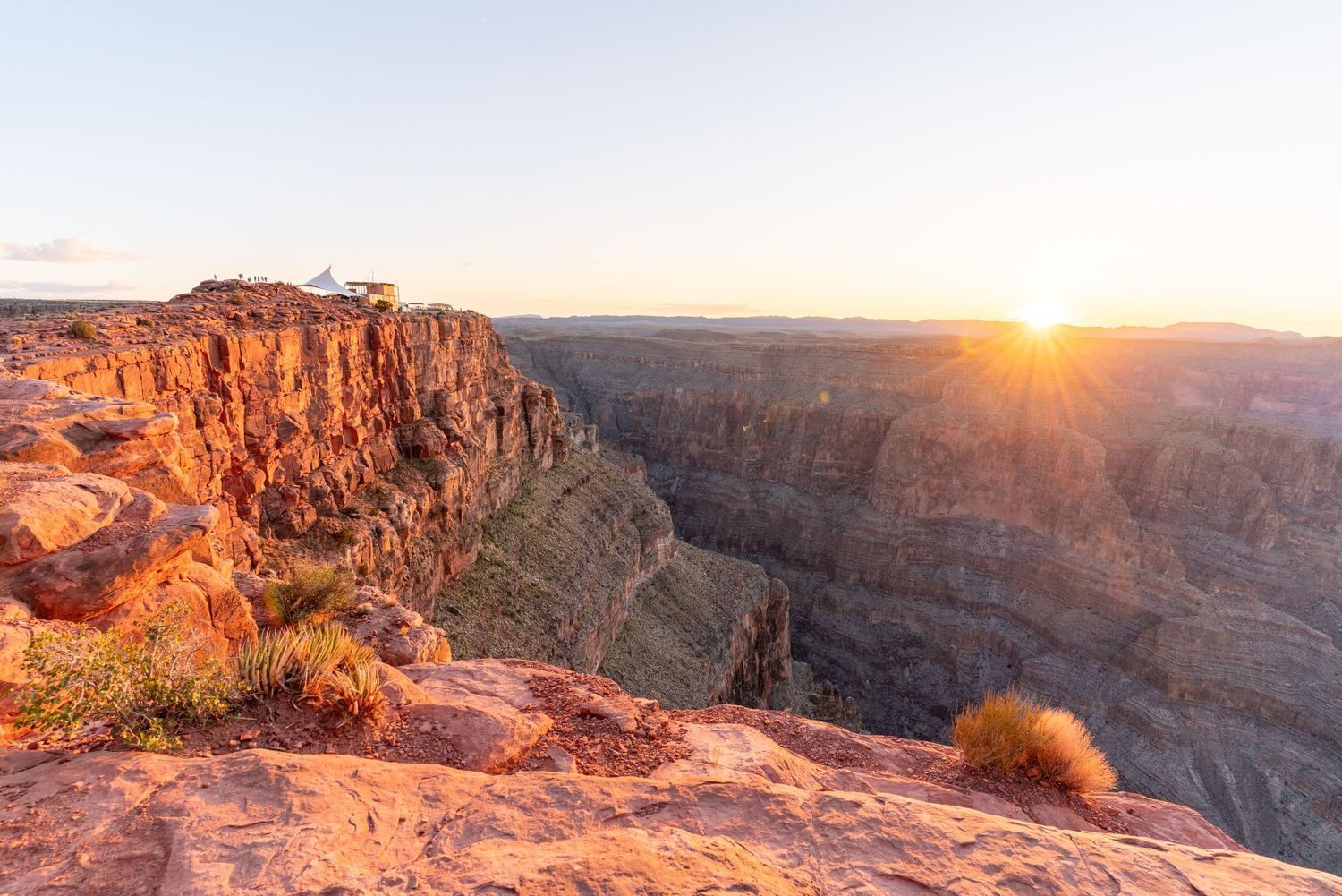 Stunning panoramic view of red rock canyon formations illuminated by golden sunset light.