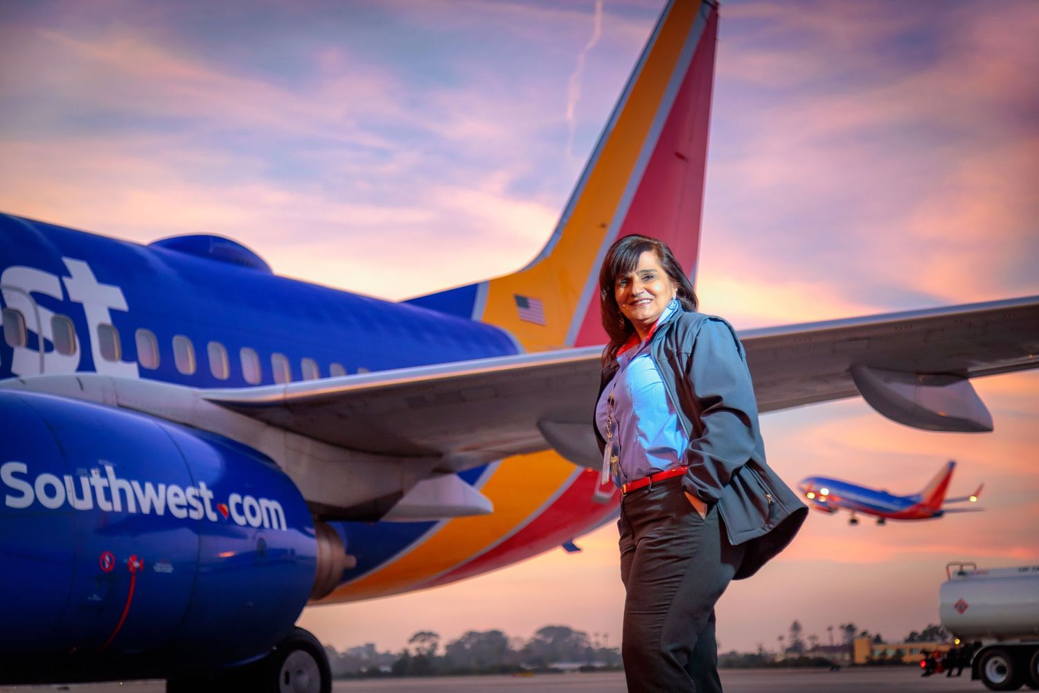 Southwest Airlines planes parked at airport gates during a colorful sunset.