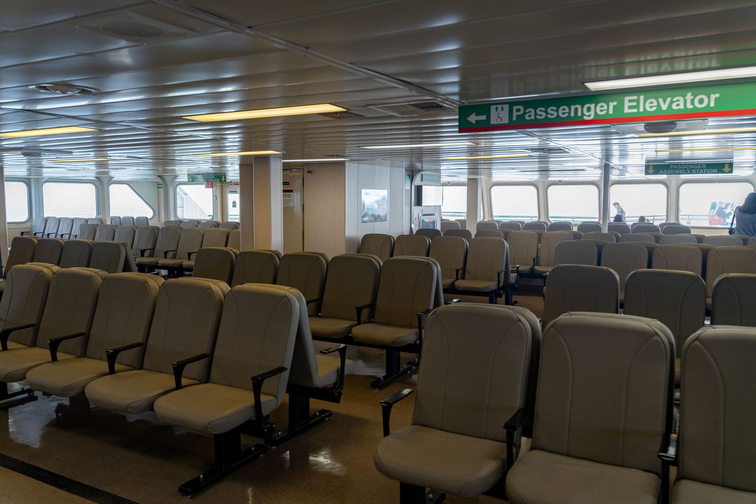 Ferry terminal interior corridor with passenger elevator and seating areas.