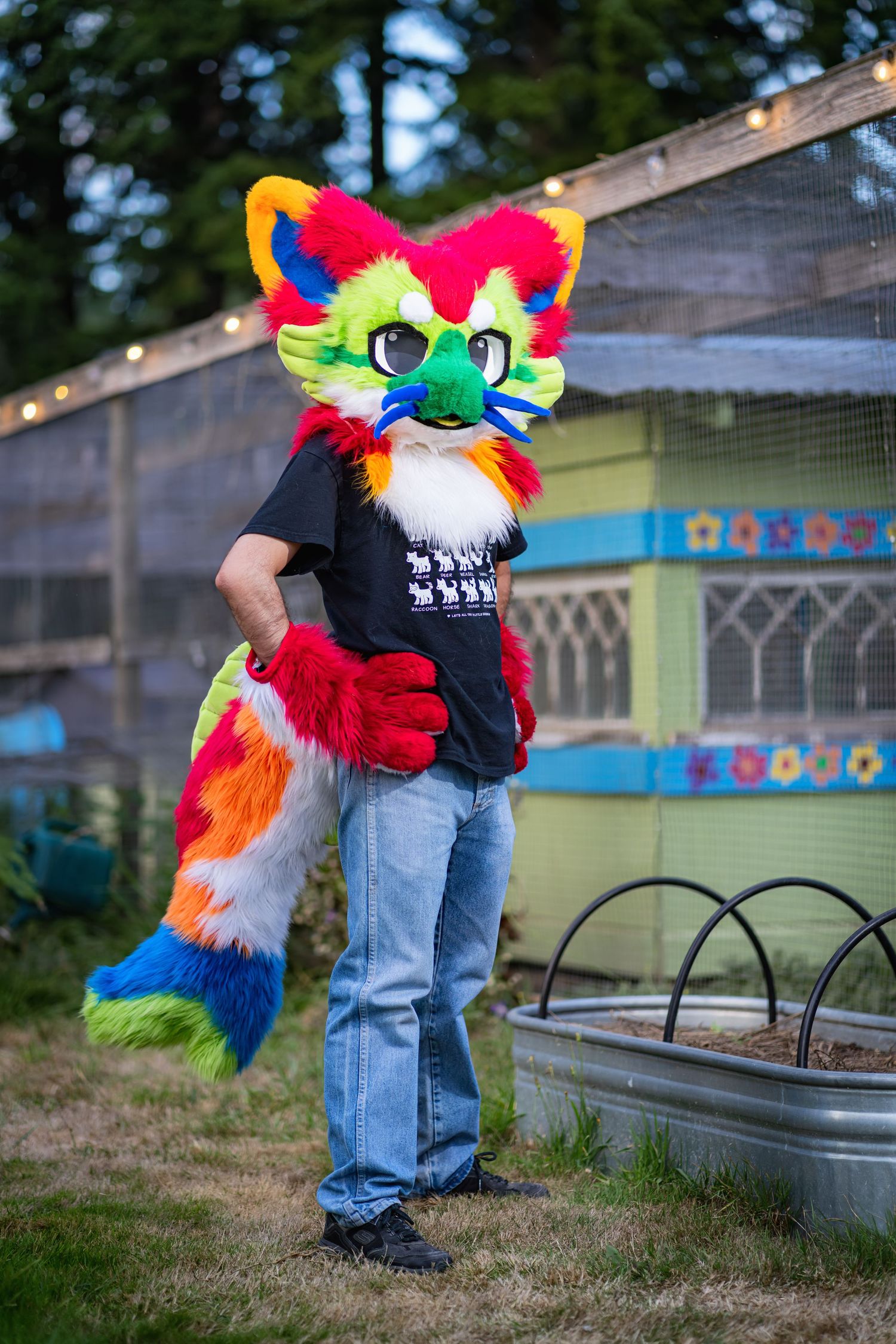Colorful fursuit characters with bright fur and costumes gather in an outdoor garden setting.