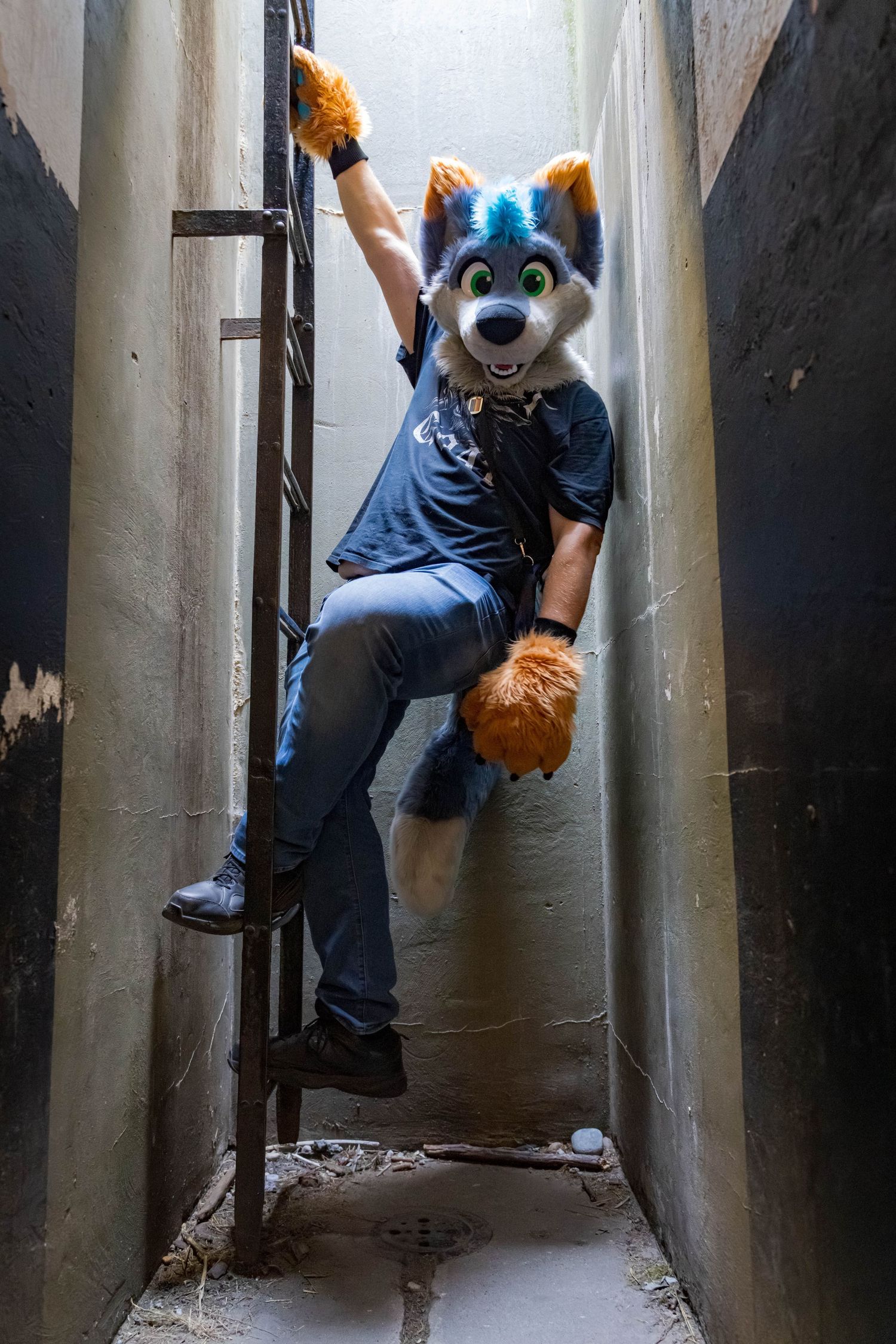 Fursuiter demonstrating wall-climbing techniques in a narrow passageway.