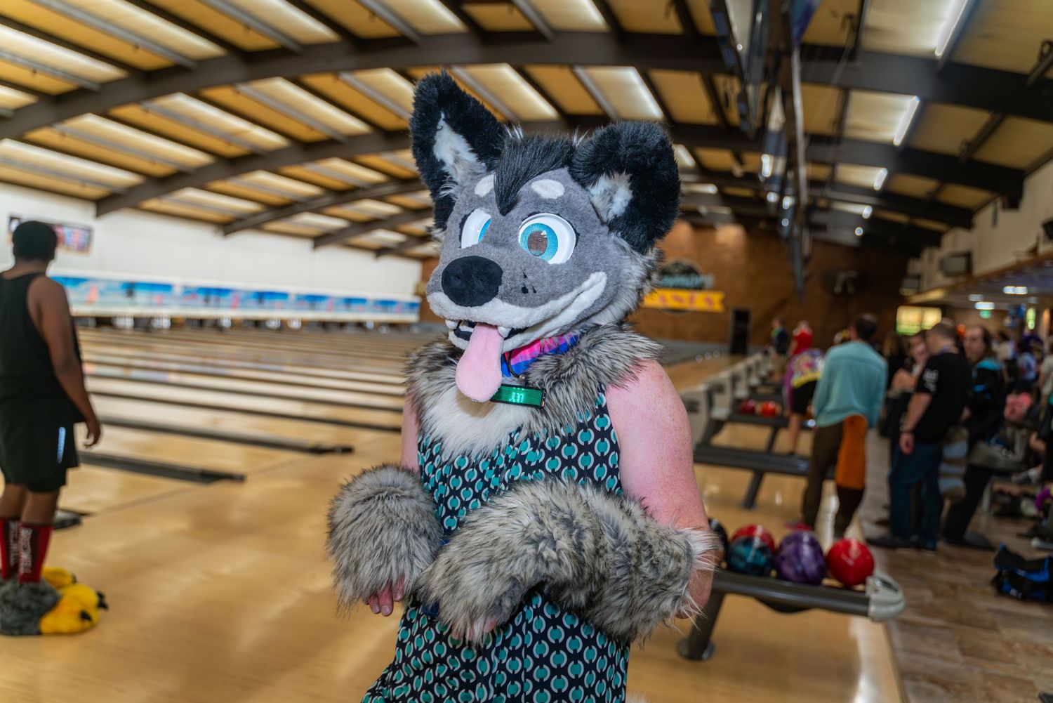 Fursuit characters posing and playing at a bowling alley event.