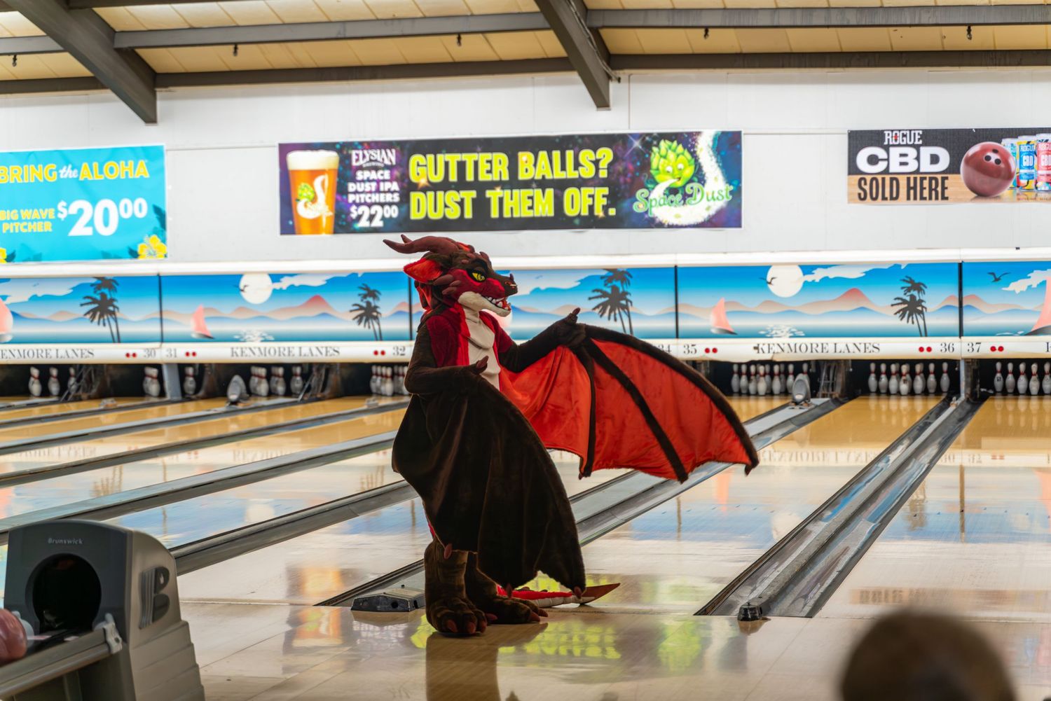 Bowling lanes with digital scoring screens and advertisements visible above.