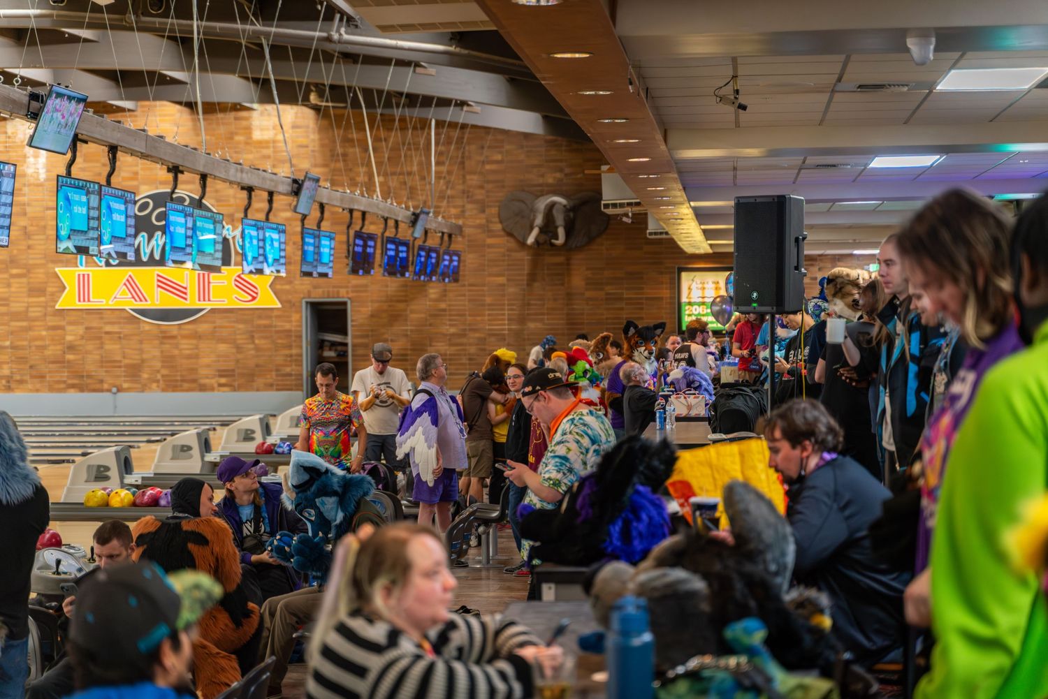 Large crowd gathered inside a bowling alley during an event.