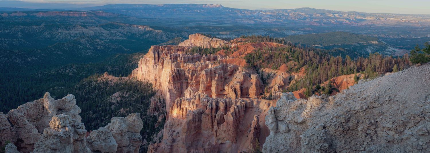 Beautiful panoramic view of red rock canyon formations stretching across mountainous landscape.