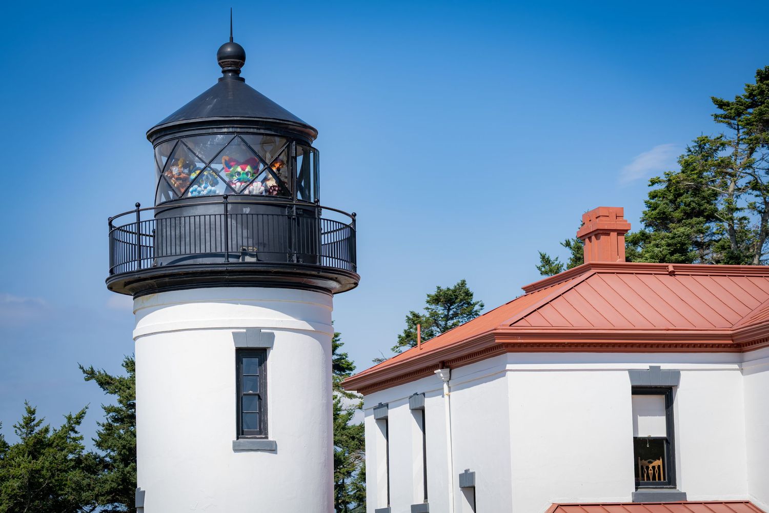 Close-up view of Admiralty Head Lighthouse's white tower and red-roofed building.