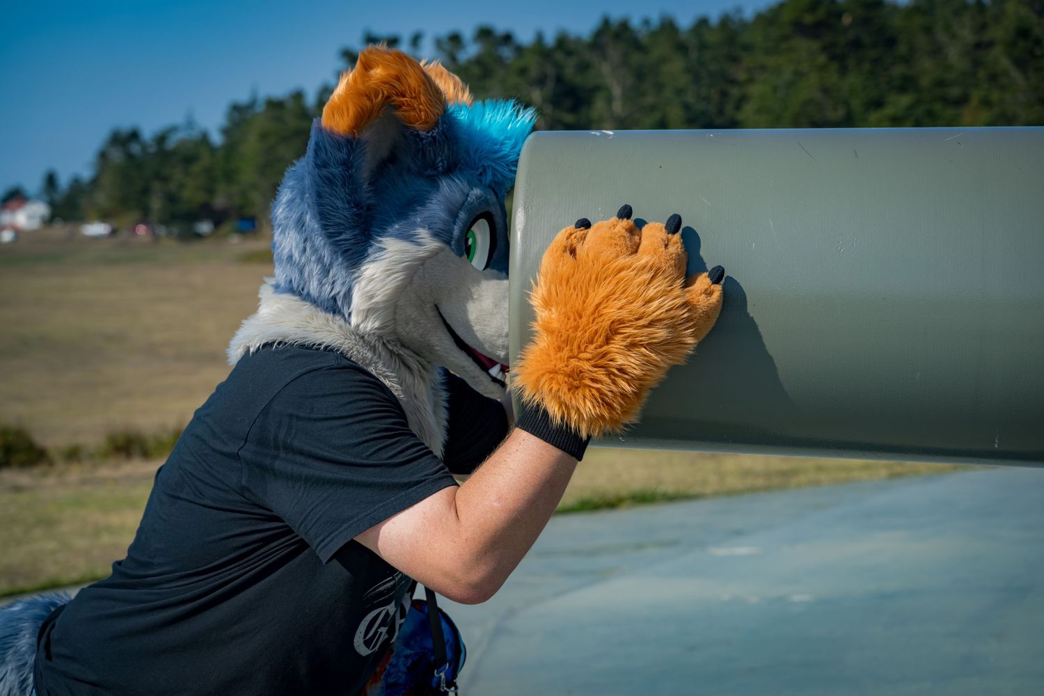 Fursuiters in bright costumes gather on a concrete platform outdoors.