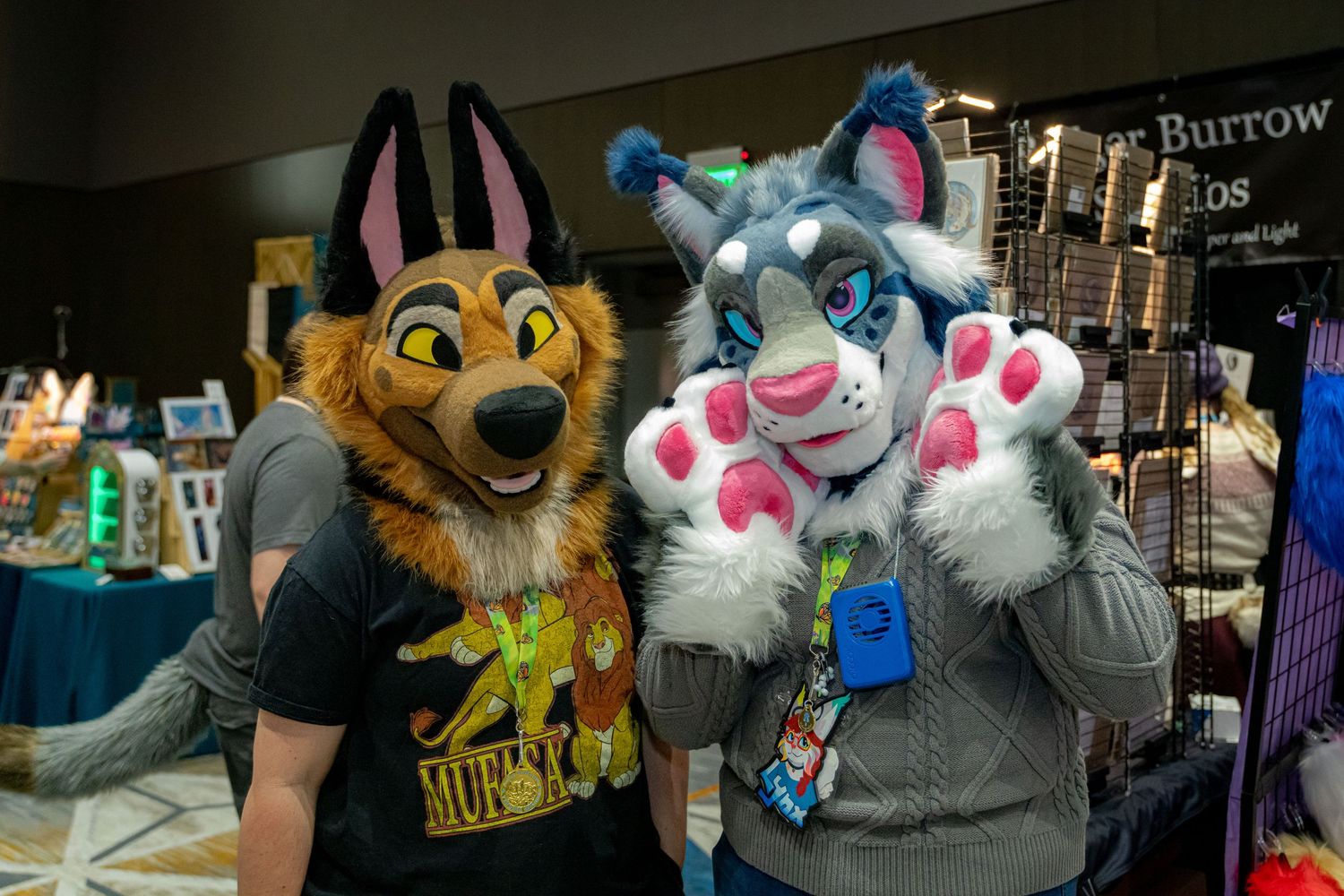 Fursuit characters pose and interact at a furry convention gathering with colorful costumes and props.