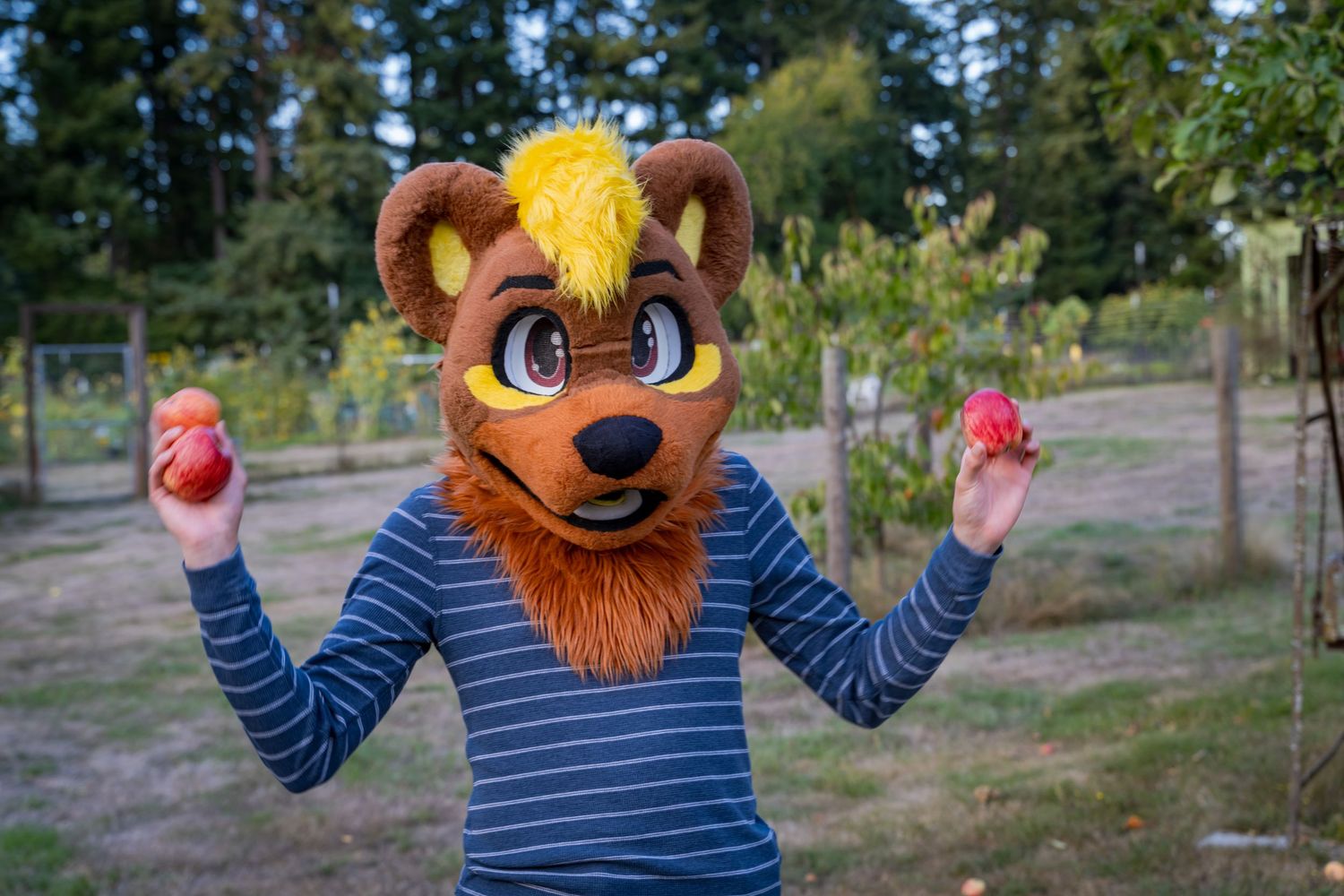 Costumed character in striped shirt poses energetically outdoors.