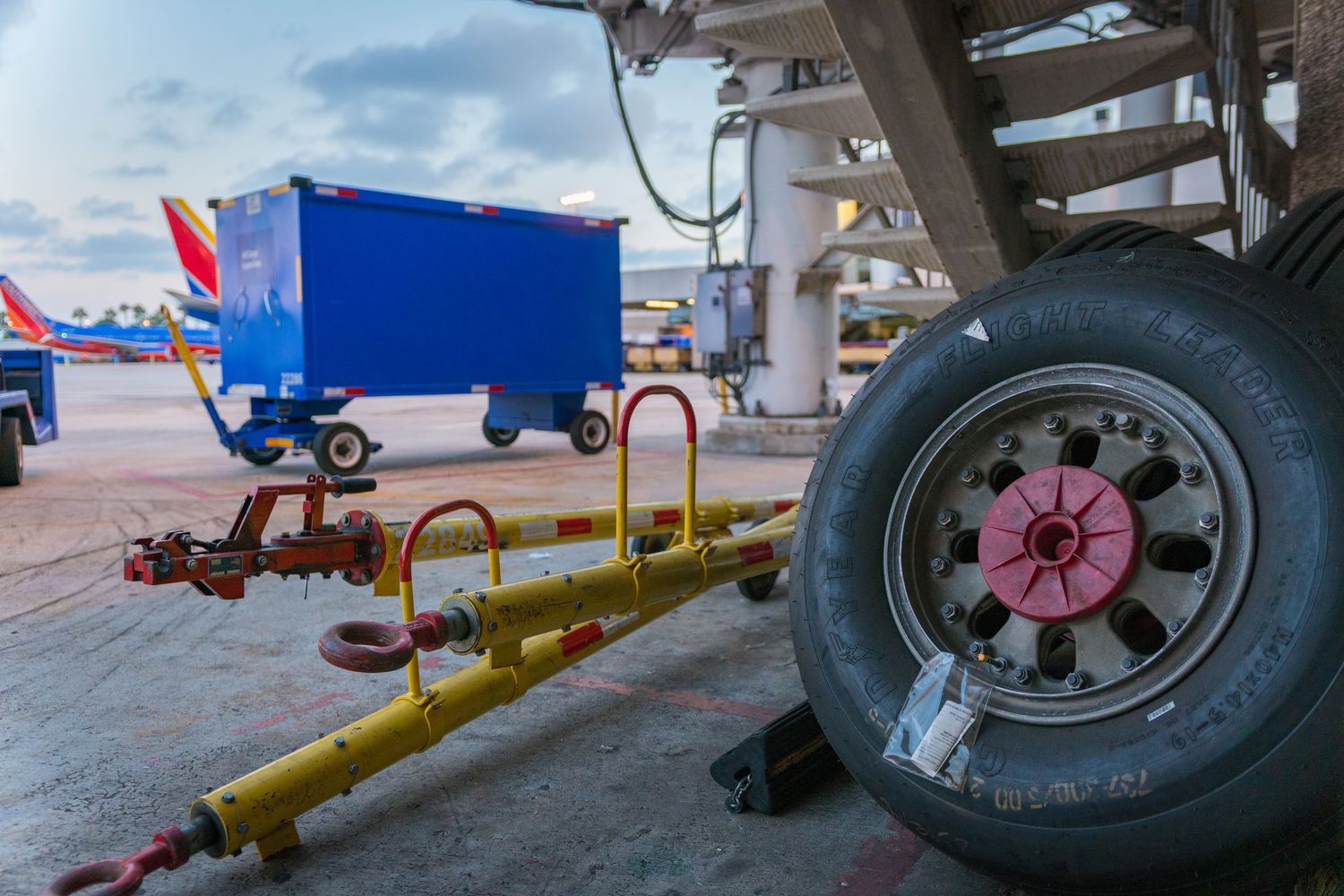 Landing gear and wheels of a commercial aircraft on airport tarmac during maintenance.
