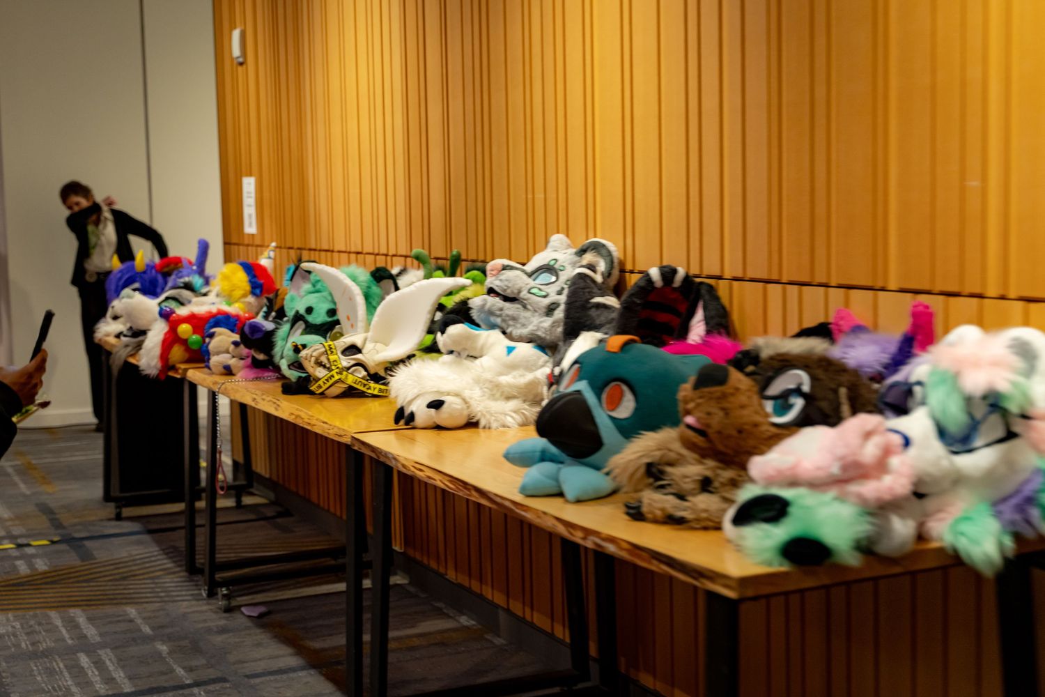 Multiple people lie sleeping on wooden benches in what appears to be a public waiting area.