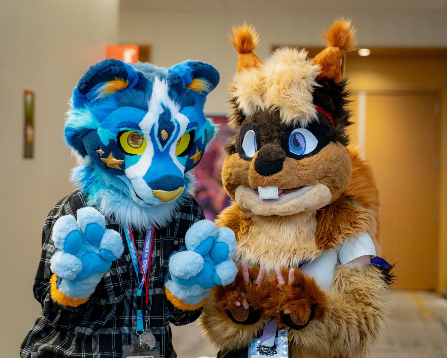 Colorful fursuit characters with blue and brown fur posing together in an indoor setting.