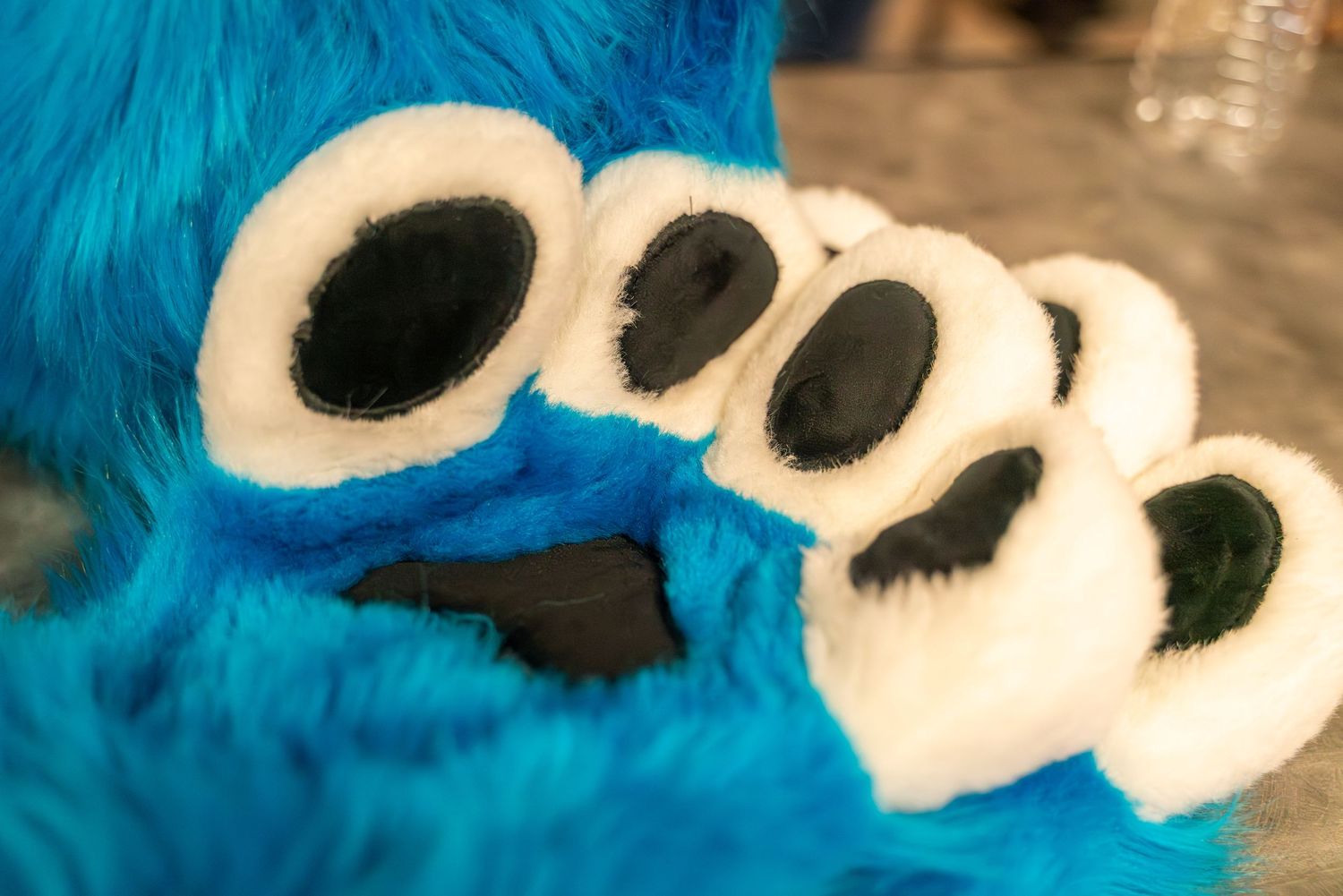 A group of blue and white fursuit parts laid out at a bowling alley.