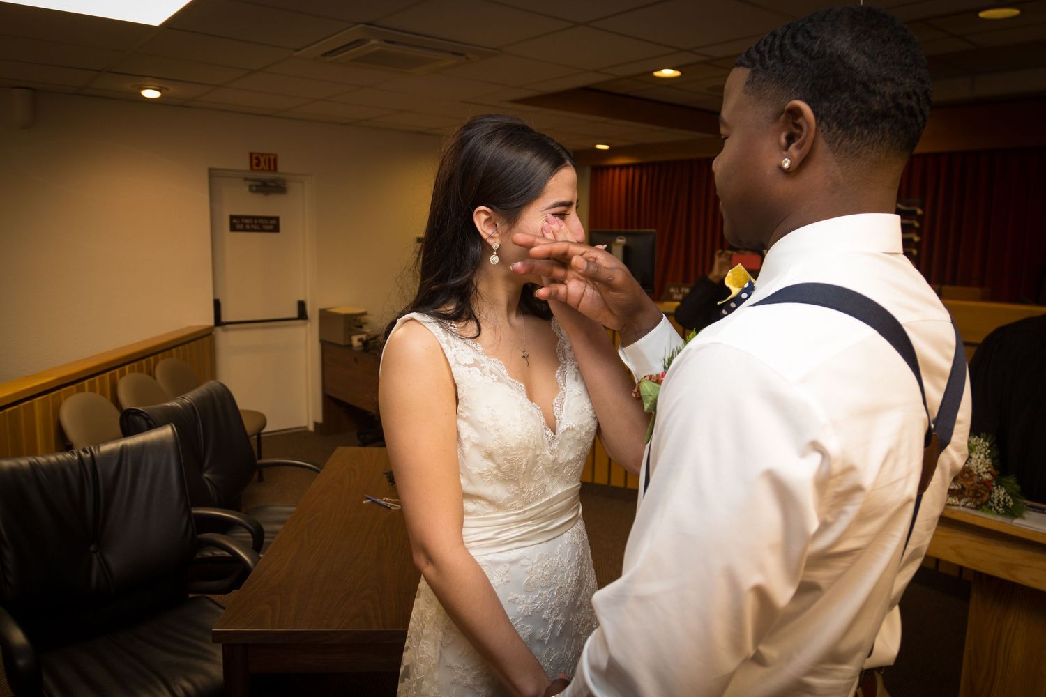 Dancing couples glide across a wooden dance floor at an elegant indoor reception venue.