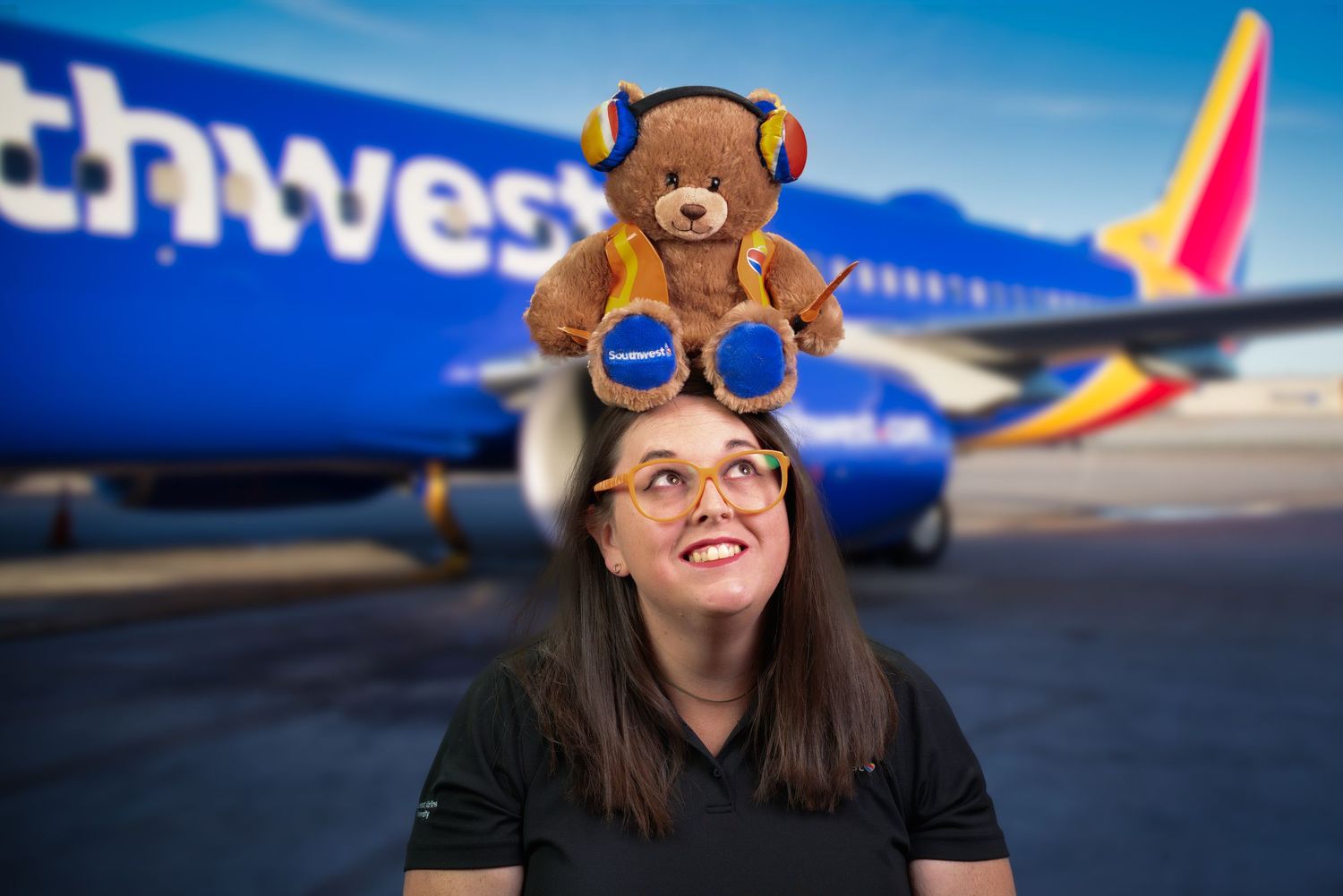 Southwest Airlines plane on tarmac with teddy bear mascot in foreground.