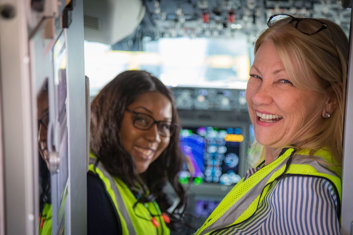 Airlines staff working in modern aircraft cockpit with digital instruments.