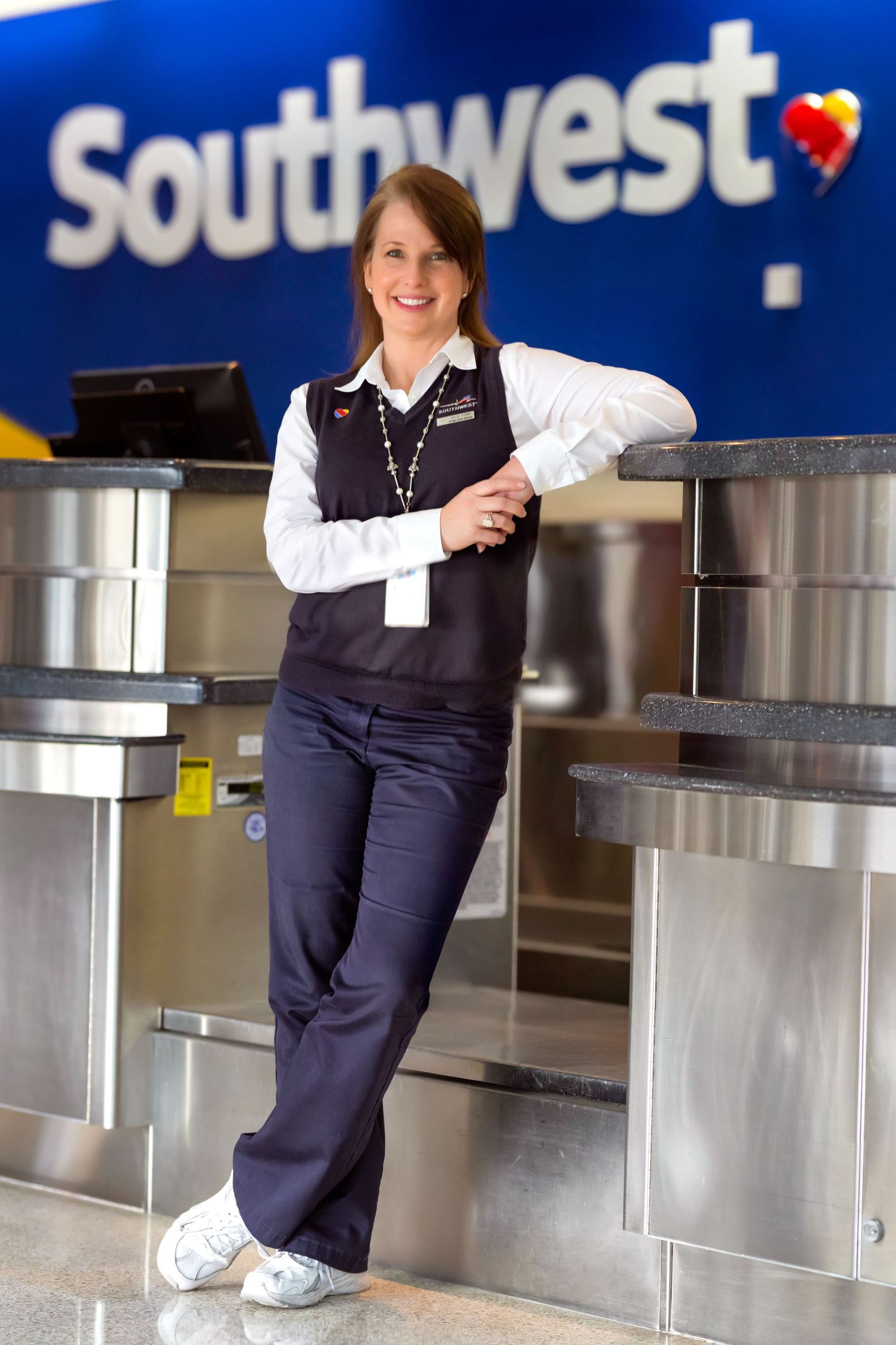 Southwest Airlines check-in counters with distinctive branding and staff in navy uniforms.