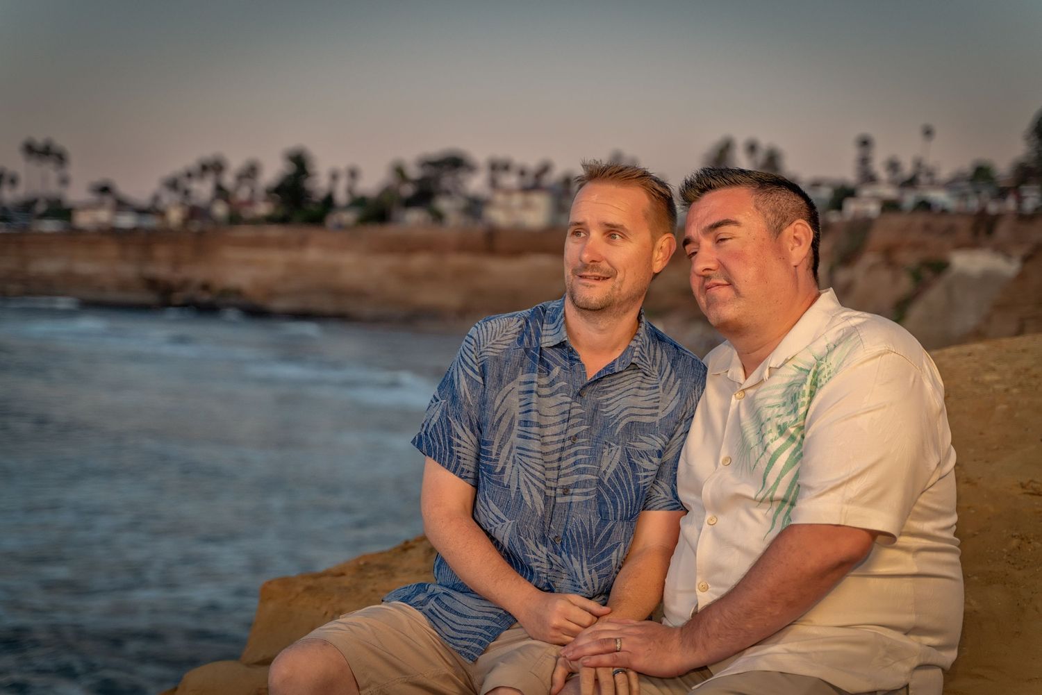 Couple enjoying a romantic moment at sunset by the ocean.