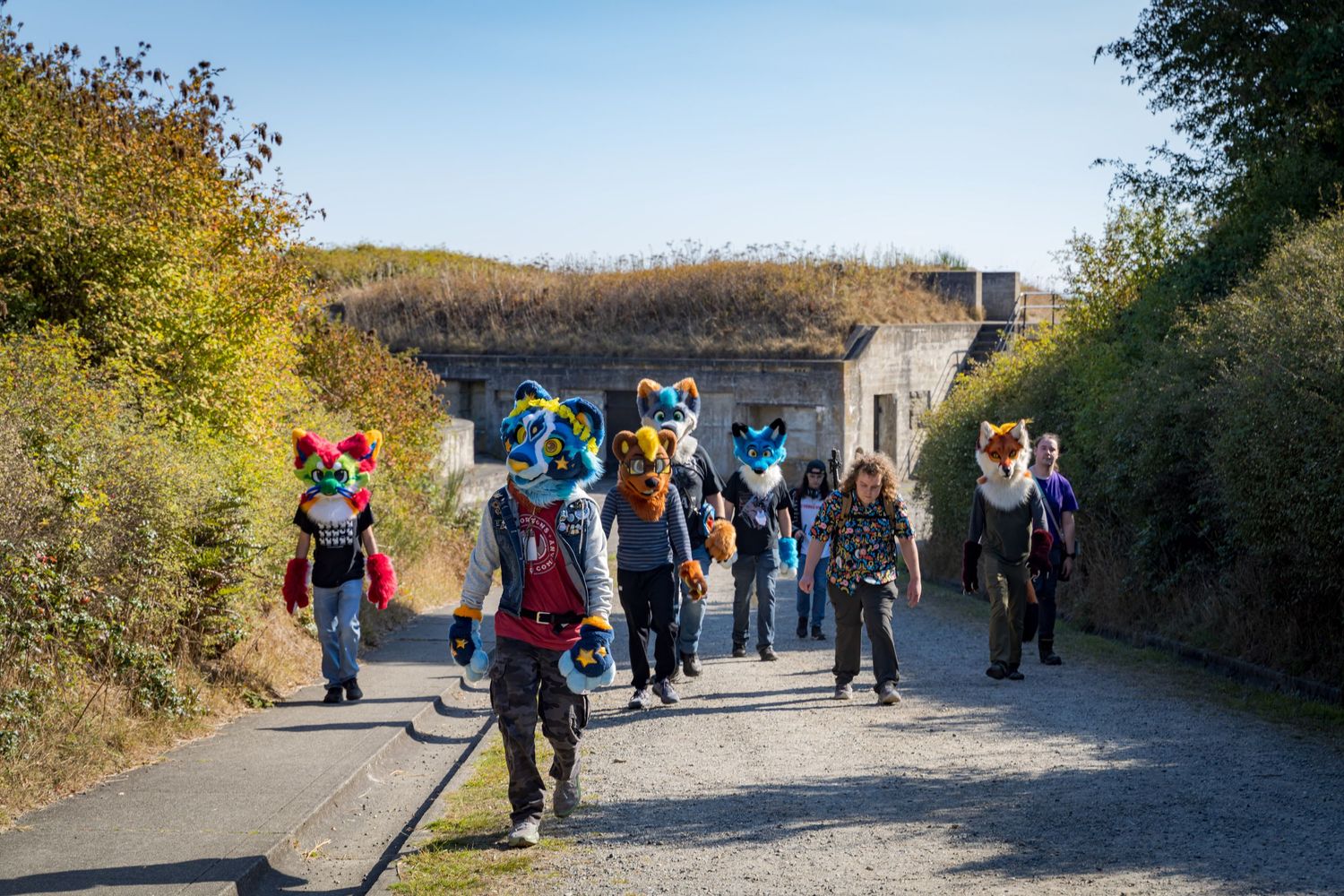 Visitors explore walkways around historic concrete military bunkers on a sunny autumn day.